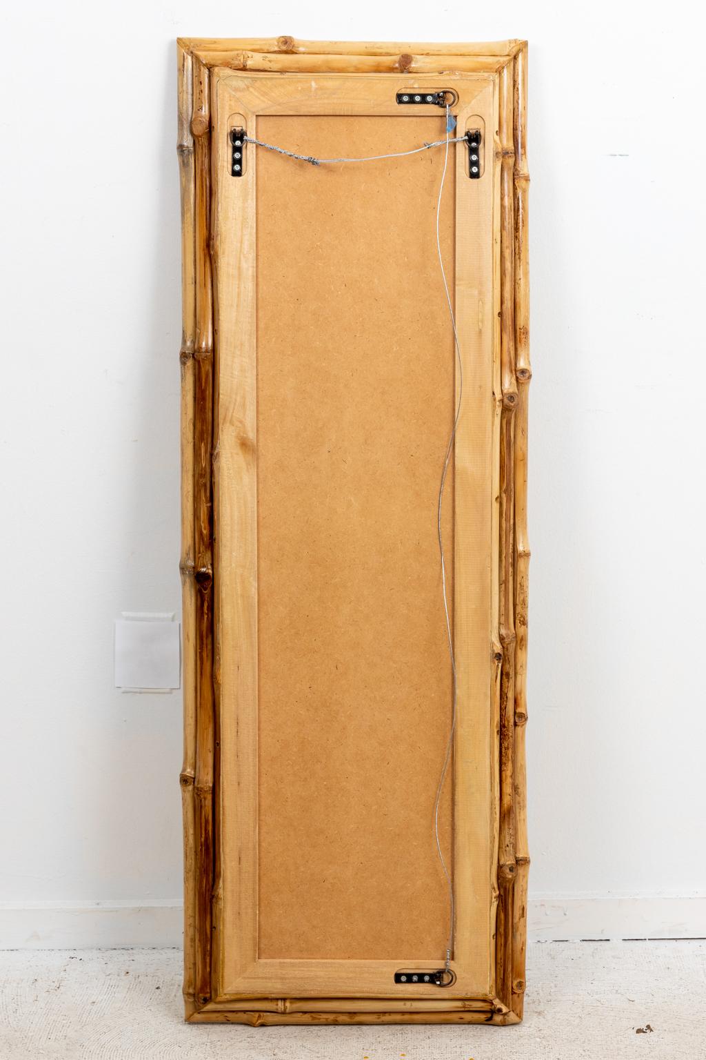 Circa 2000 light wood bamboo mirror with beveled mirror plate that can be hung vertically or horizontally. Please note of wear consistent with age including minor finish loss to the frame.