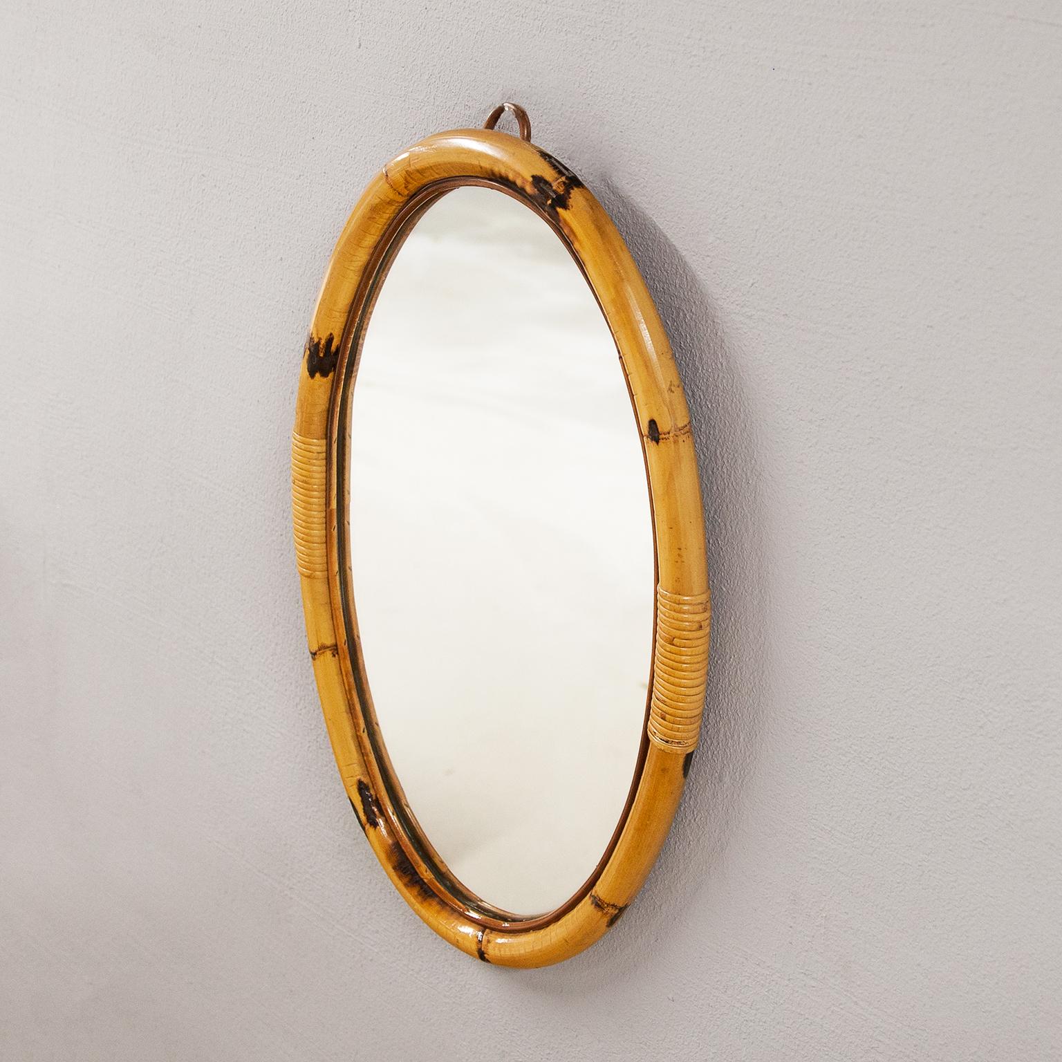 Beautiful French Riviera mirror, manufactured in France in the 1950s and used in many summer houses of the Cote d’Azur. The huge oval frame is made of strong bamboo.