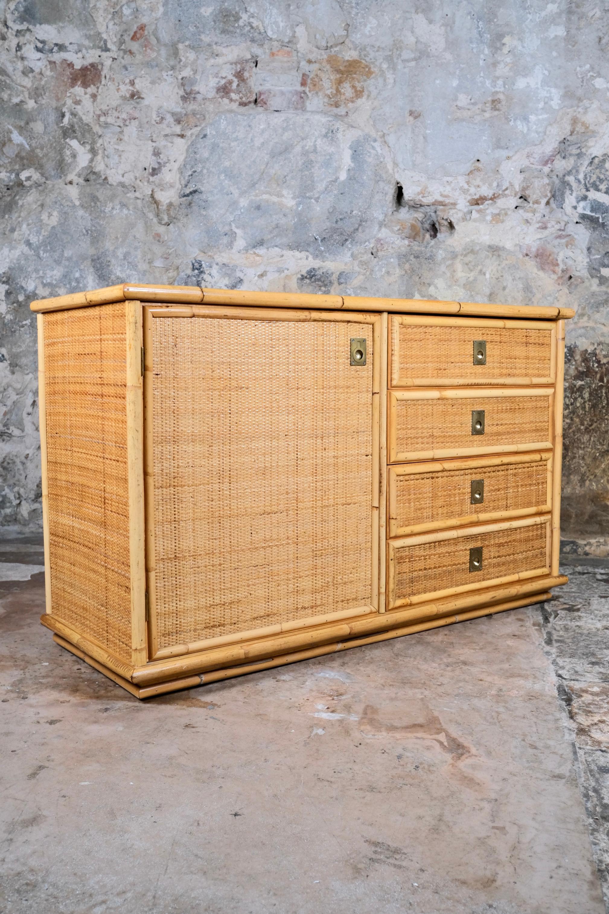 Bella credenza o cassettiera in bambù, rattan intrecciato e ottone, realizzata da Dal Vera in Italia nel 1979.
A sinistra, un'anta con due vani portaoggetti, a destra, quattro cassetti.
Inciso e datato sul retro.
Nel complesso buone condizioni,