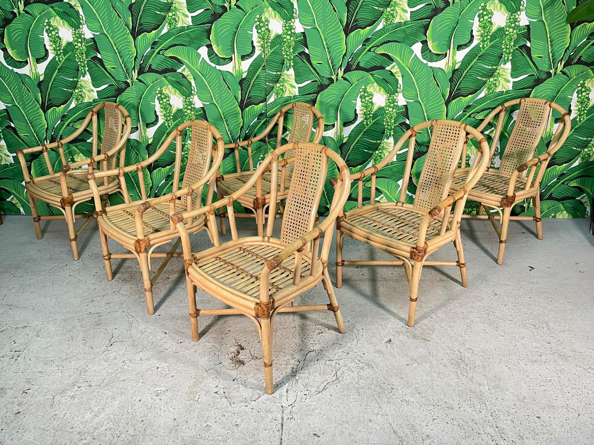 Set of 6 rattan barrel-shaped arm chairs by Drexel Heritage feature bow back with cane insert and leather strapping. Good condition with imperfections consistent with age, see photos for condition details. 
For a shipping quote to your exact zip