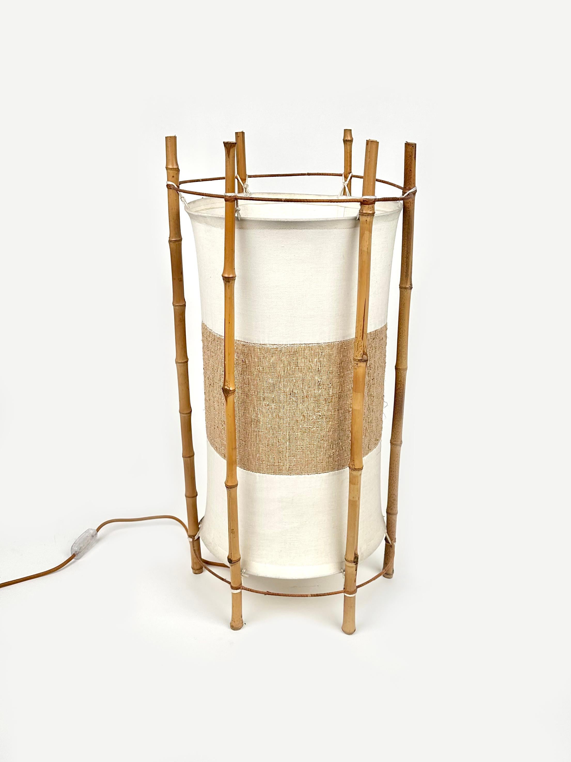 Amazing cylindrical floor lamp or table lamp in white and brown cotton featuring structure in bamboo composed of six stems in the style of to the French designer Louis Sognot. 

Made in Italy in the 1960s.

Electrical system has been renewed.