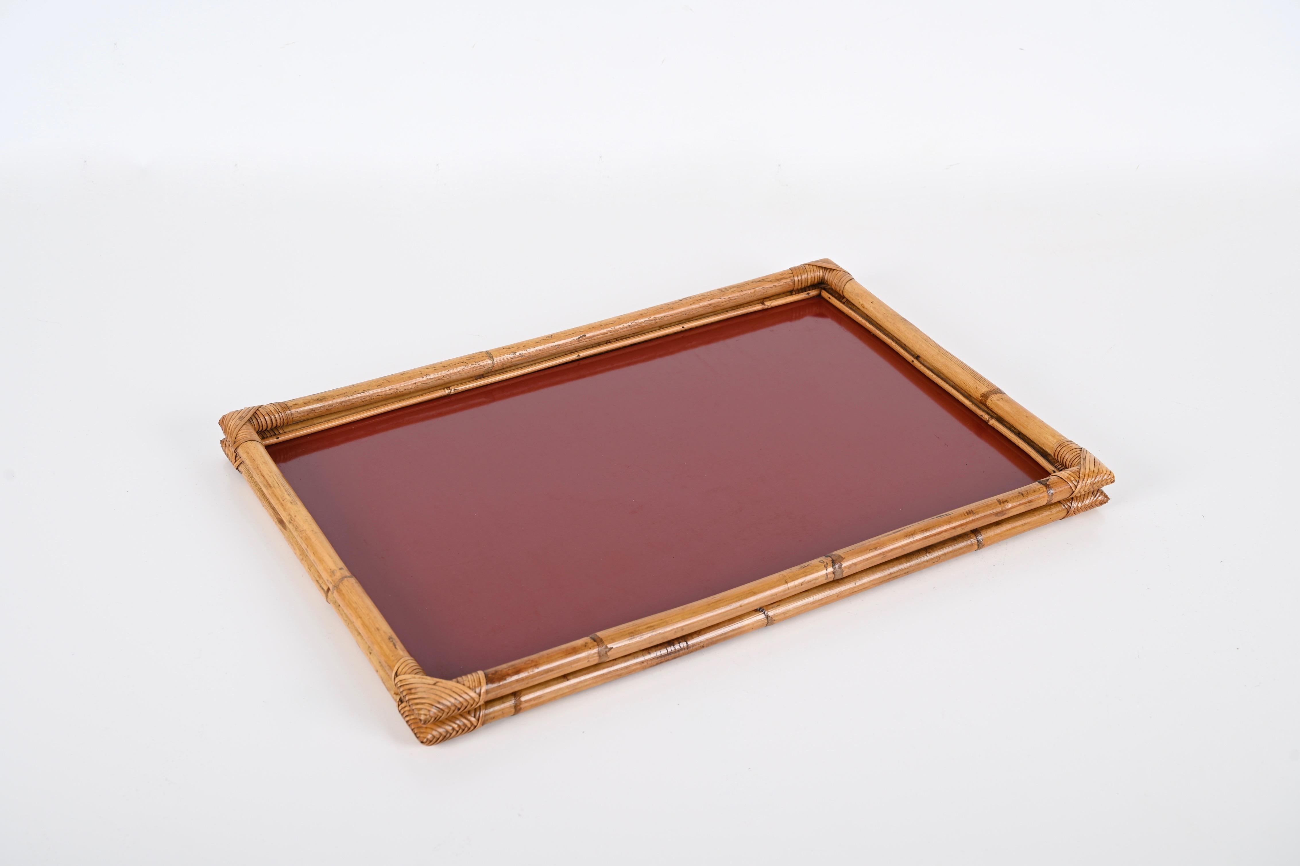 Fantastic serving tray in bamboo, rattan wicker and red bakelite. This gorgeous piece was realized by Cesare de Cesare in Italy in the 1970s and still has its brass signed plate on the back. 

The serving tray features a double frame in bamboo