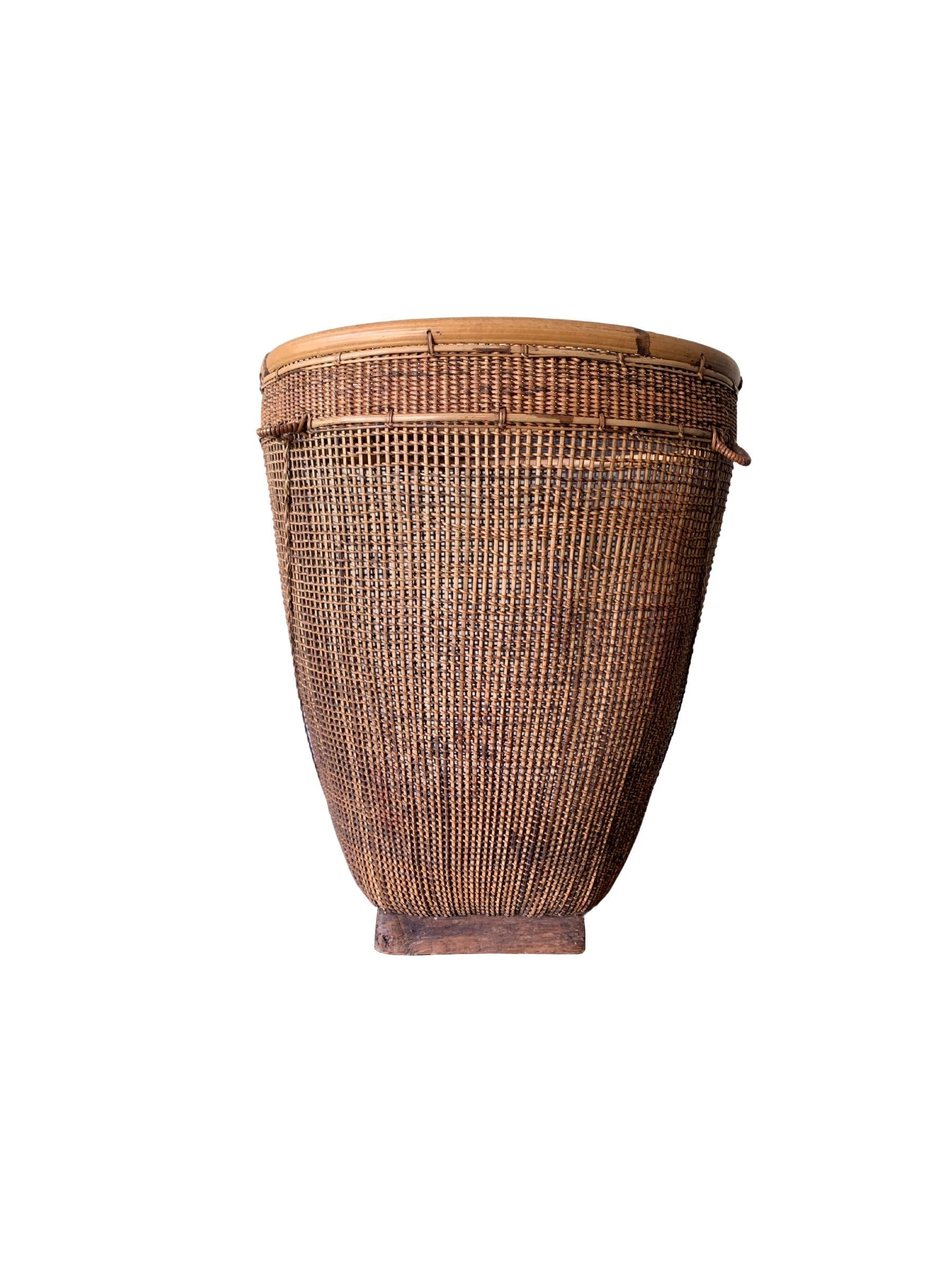 Ce panier tressé à la main au milieu du XXe siècle provient de la tribu Dayak de Bornéo et est fabriqué à partir de fibres de bambou et de rotin. Le cadre est fabriqué en bambou et la combinaison des techniques de tissage du bambou et du rotin crée