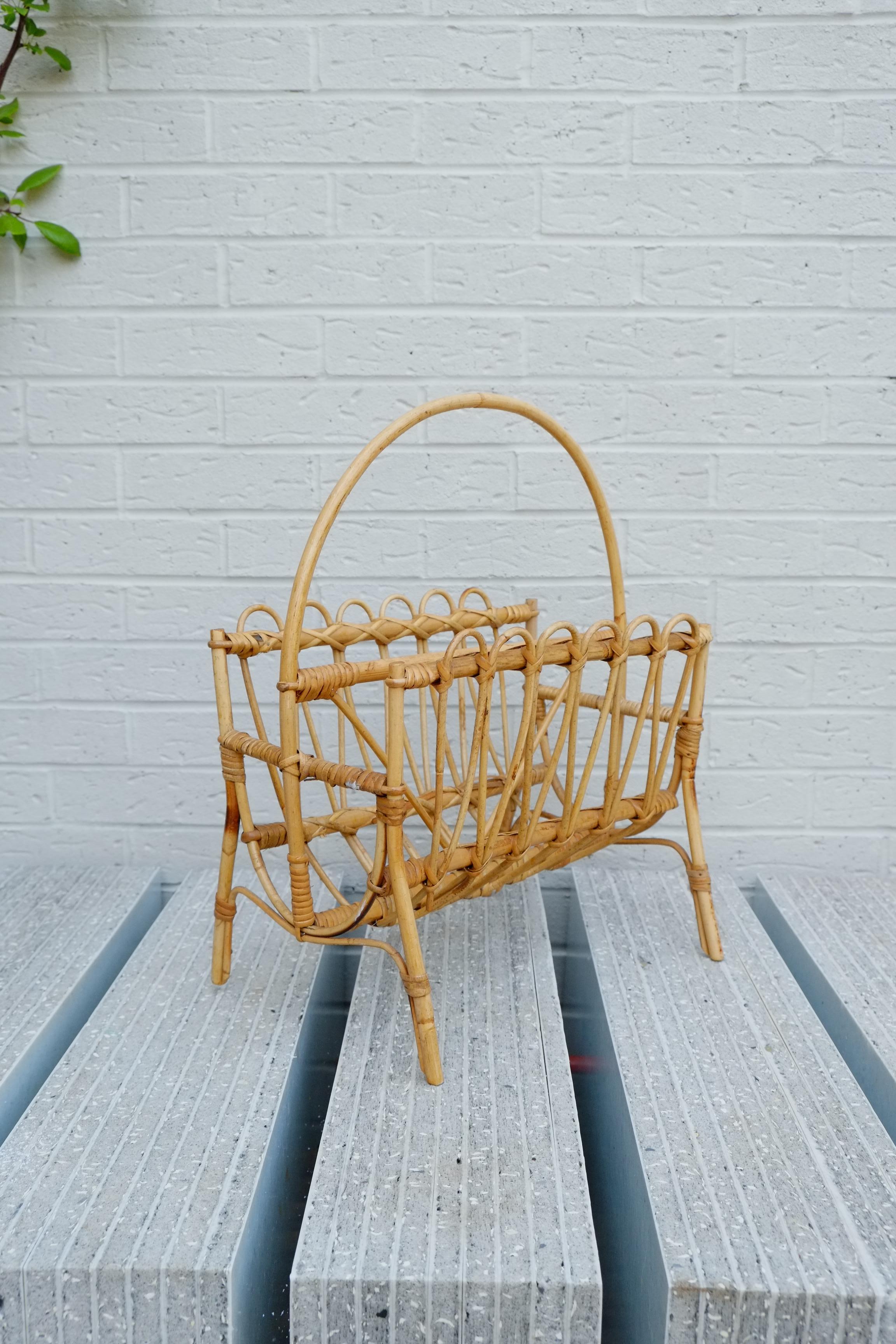 Beautiful 1960s Mid-Century Modern magazine rack stand in bamboo. The organic beauty of the woven materials is timeless and classic, making bamboo and rattan furniture incredibly versatile. This piece has a particularly elegant and light decorative