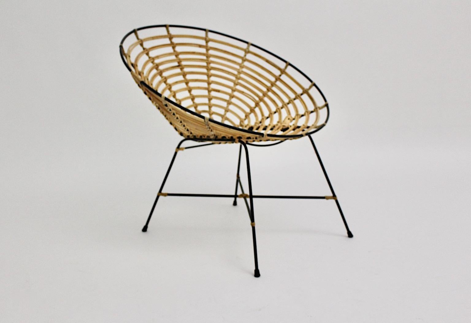 Une chaise longue vintage en bambou et rotin de couleur marron, conçue et fabriquée en Italie dans les années 1960.
La coque d'assise en bambou ajouré de style Riviera et la structure en métal laqué noir complètent le design vivable et