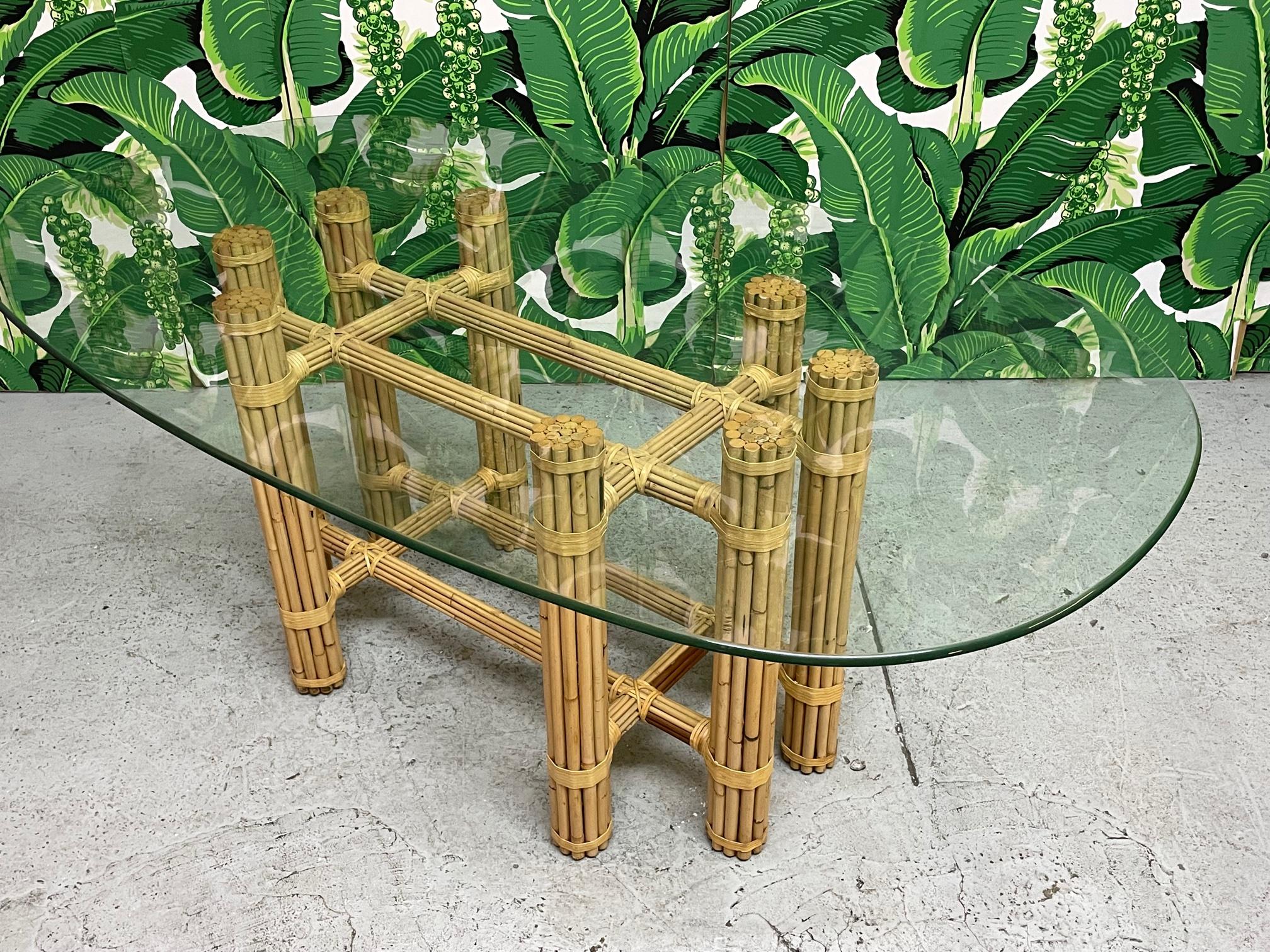 Bamboo rattan glass top dining table in the style of McGuire. Simple and elegant organic modern style. Rattan poles lashed together with leather rawhide laces. Glass top is 5/8