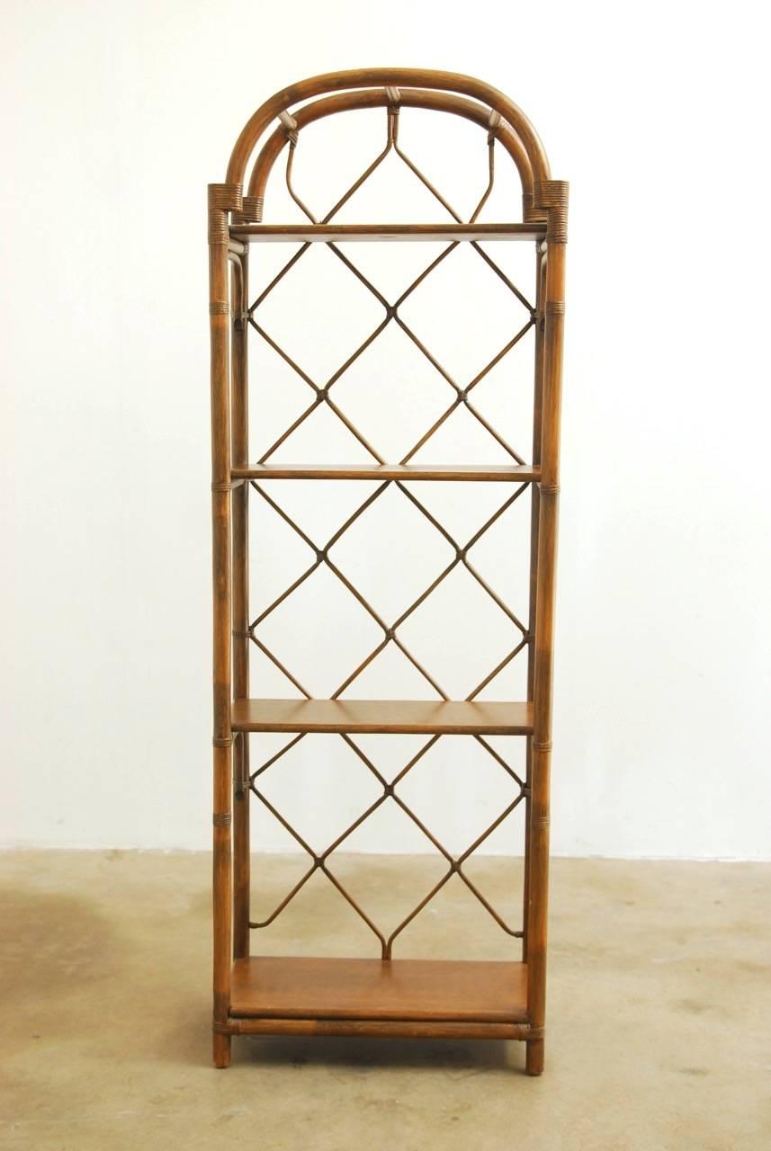 Organic modern display shelves or bookcase by Brown Jordan constructed from bamboo and rattan. Featuring a decorative open fretwork design lattice. Four shelves surmounted by a domed top. Made in the manner and style of McGuire.