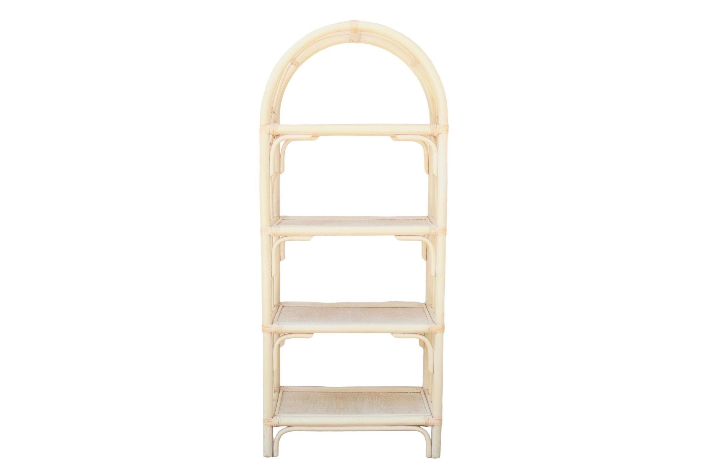 An arched bamboo & rattan etagere. Bent bamboo forms the frame, supporting four woven rattan shelves. Sides are decorated with pencil wood bamboo woven into lancet shapes secured with rattan wrapping. Painted throughout in a soft cream color.

