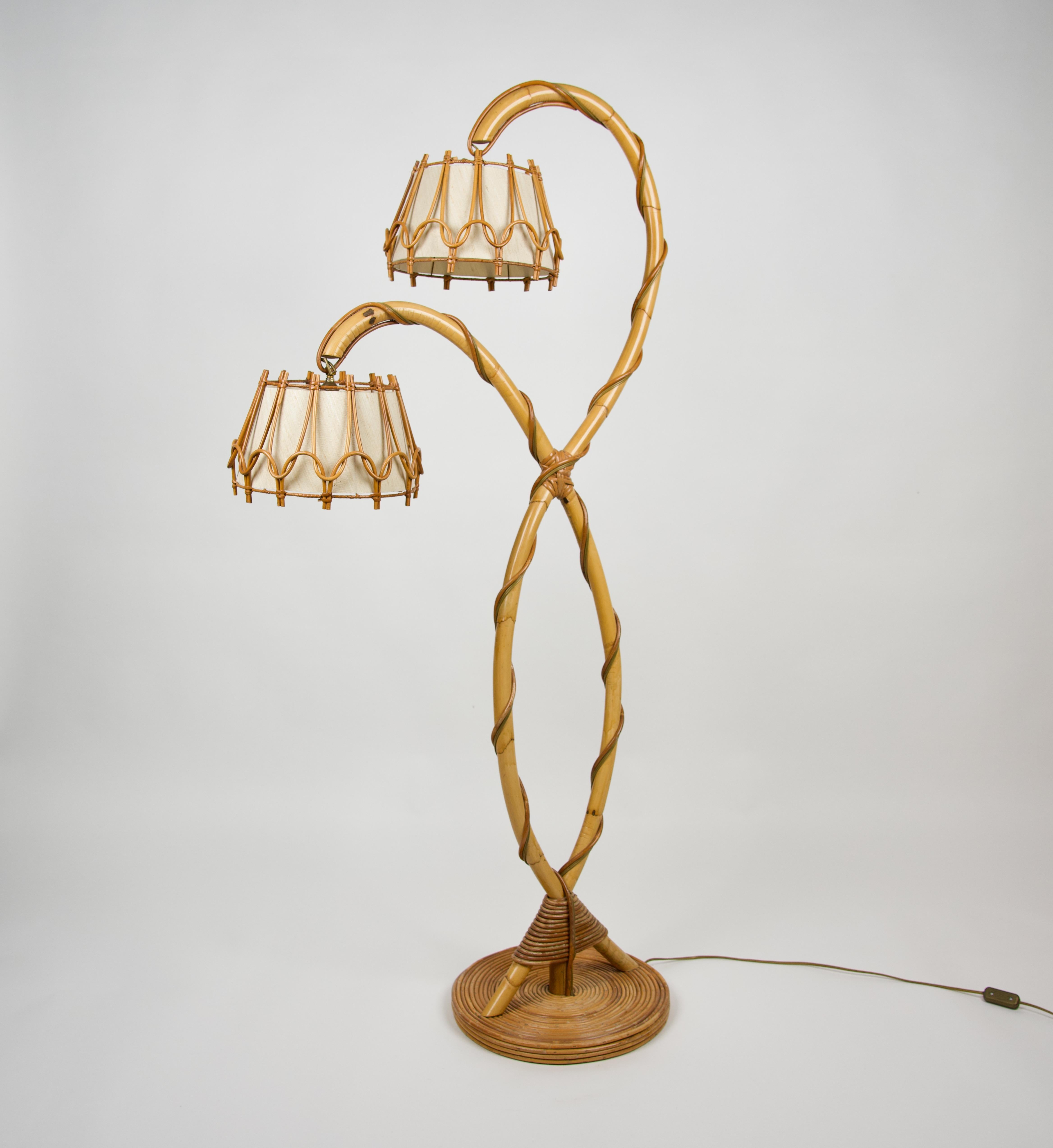 Two lights floor lamp in bamboo and rattan, elegantly intricate as to recall the branches of a tree, featuring white cotton lampshades in the style of the French designer Louis Sognot. 

Made in France in the 1960s.