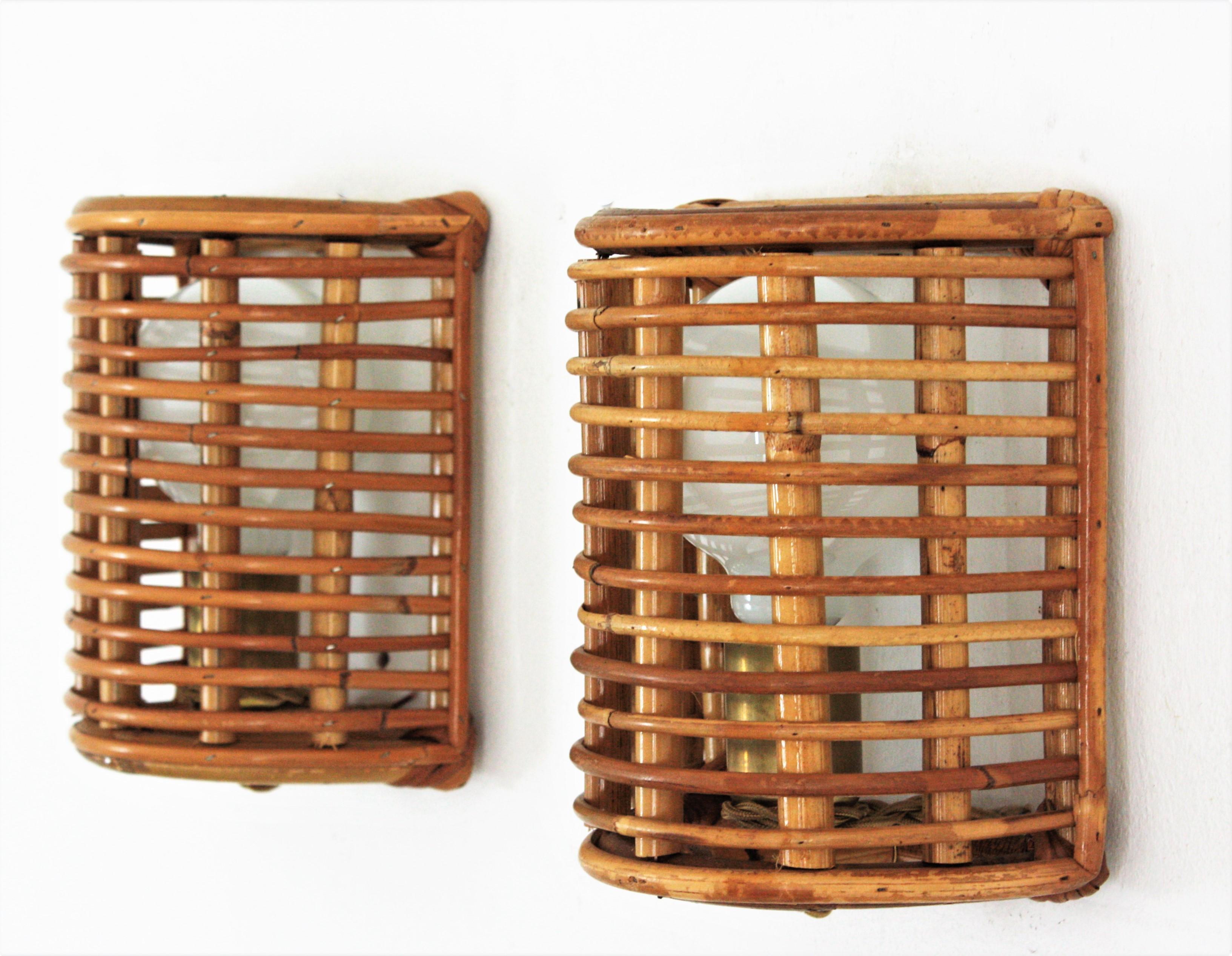 Pair of half cylinder wall lights with rattan and bamboo grid shades. Italy, 1960s.
These wall light fixtures feature a half cylinder bamboo structure covered with rattan canes in grid disposition. 
They will be the perfect choice to add a