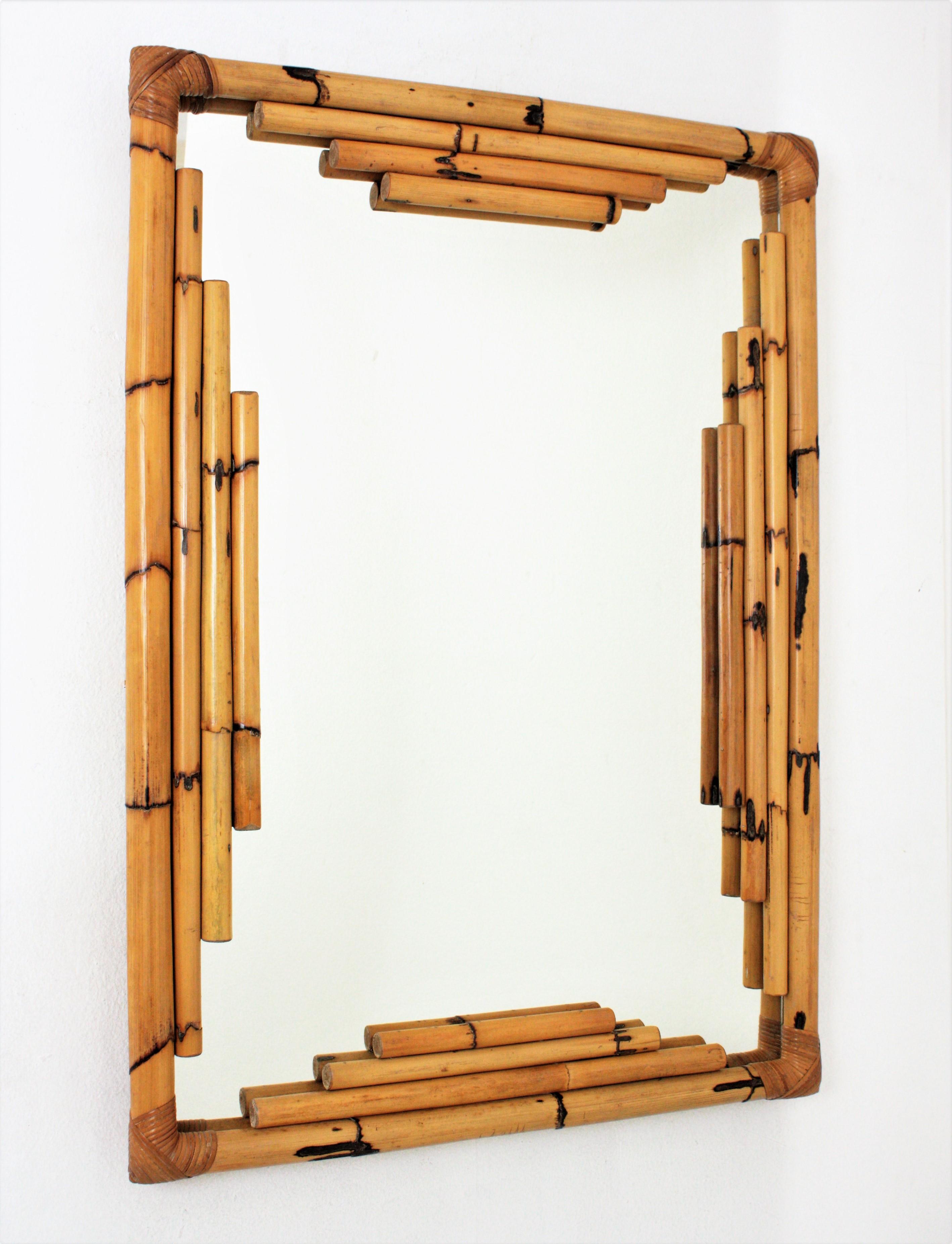 Spanish Mid-Century Modern Bamboo Chinoiserie Tiki style rectangular wall mirror. Spain, 1960s.
Gorgeous Tiki style rectangular mirror handcrafted with bamboo canes. It has a highly decorative frame with oriental inspired geometric decorations and a