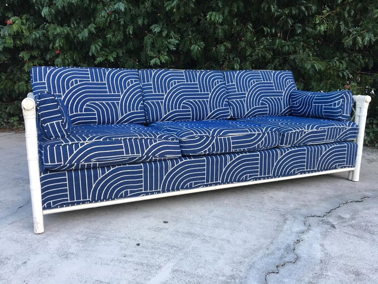 Beautiful rattan sofa features deep blue fabric with a modern print and woven rattan sides. Good vintage condition with no stains or tears to fabric. Minor wear to frame consistent with age.
 