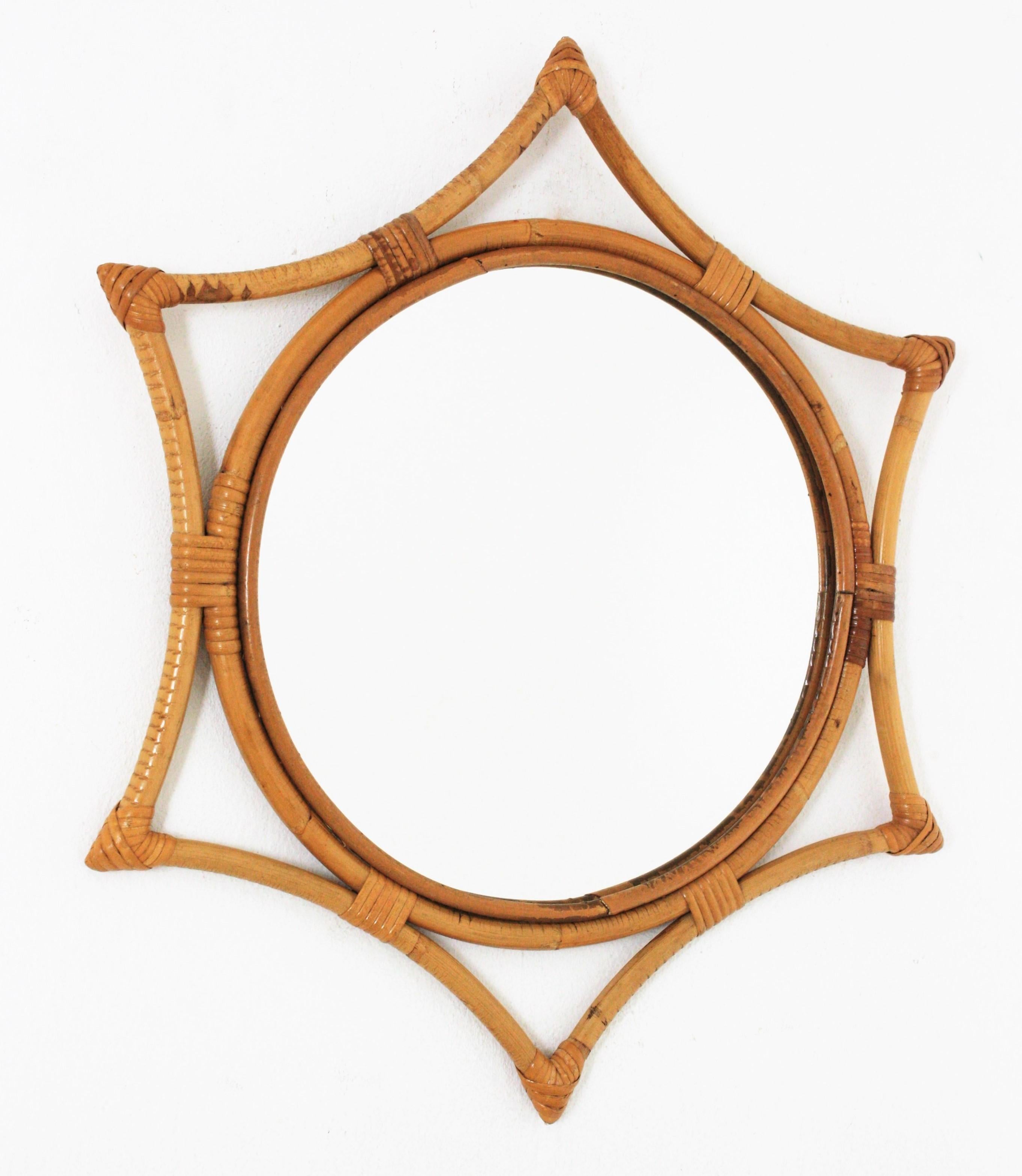 Midcentury bamboo rattan sunburst starburst mirror. Spain, 1960s.
This wall mirror features a round mirror glass framed by a bamboo star shaped frame with wicker /rattan tied accents.
Beautiful placed alone but also interesting as a part of a wall