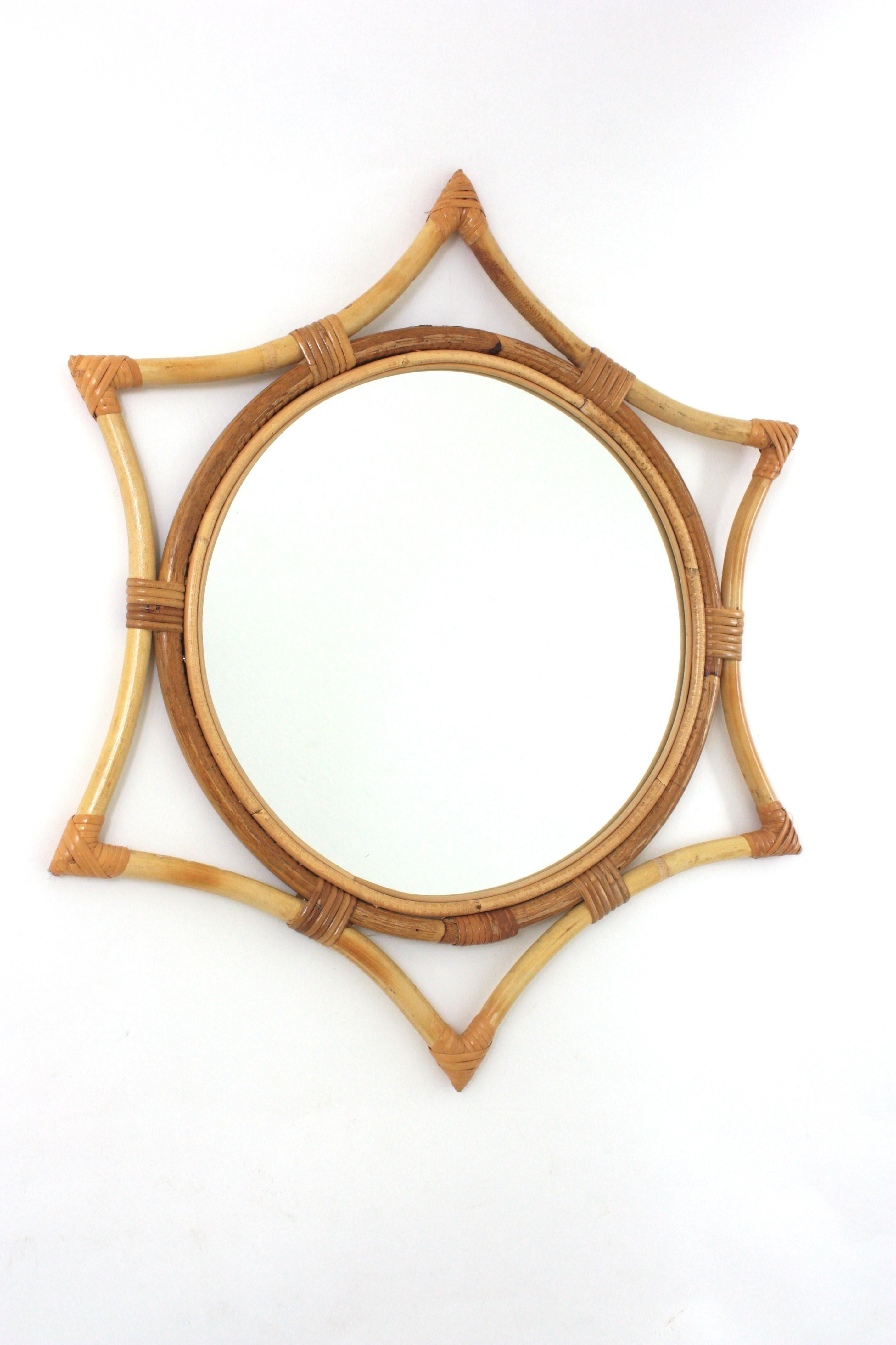 Specchio moderno di metà secolo in rattan di bambù a raggiera. Spagna, anni '60.
Questo specchio da parete è caratterizzato da un vetro a specchio rotondo incorniciato da una cornice a forma di stella in bambù con accenti in vimini/rattan legati