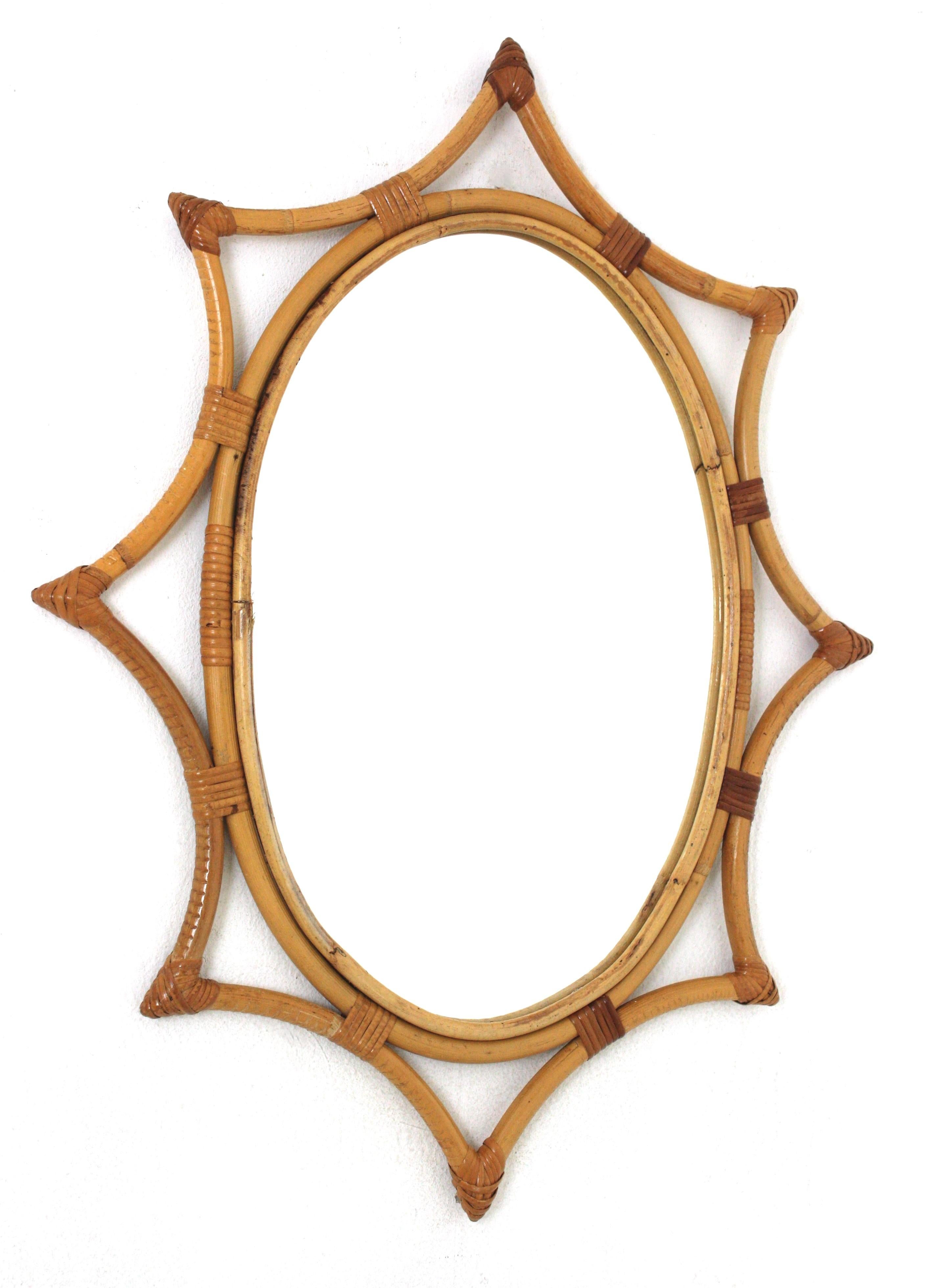 Oval Midcentury bamboo rattan sunburst starburst mirror. Spain, 1960s.
This wall mirror features an oval mirror glass framed by a bamboo star shaped frame with wicker /rattan tied accents.
Beautiful placed alone but also interesting as a part of a