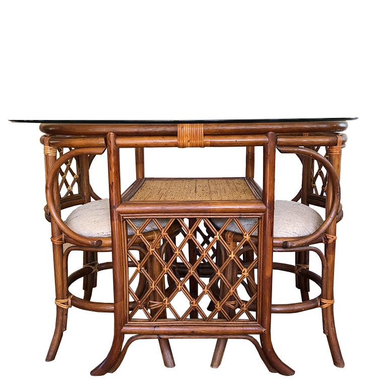 Tigerwood bamboo table chairs cane details conversation set or dining table. The dining set is composed of tiger wood or tortoise wood, bamboo, wicker or rattan. A glass top rests on the top of the table. Secondary shelf made of cane and wood under