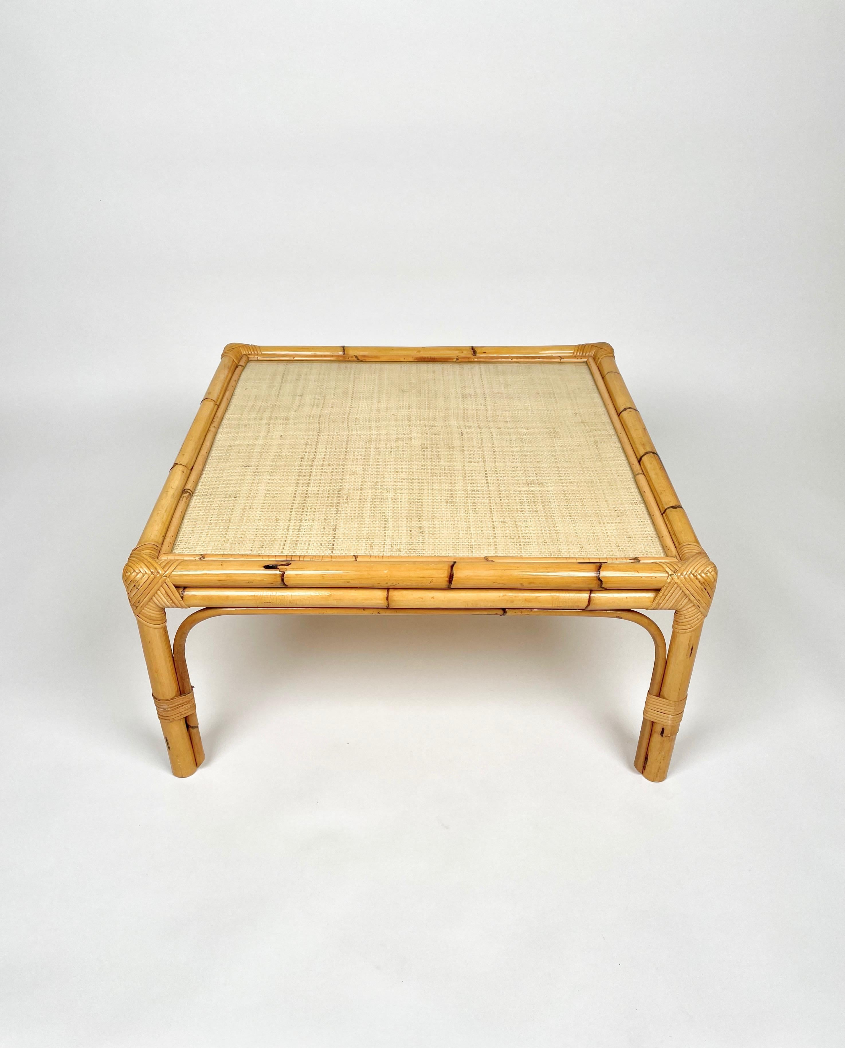 Squared coffee table in bamboo & rattan with wicker surface covered by a transparent glass layer. 

Made in Italy in the 1960s.