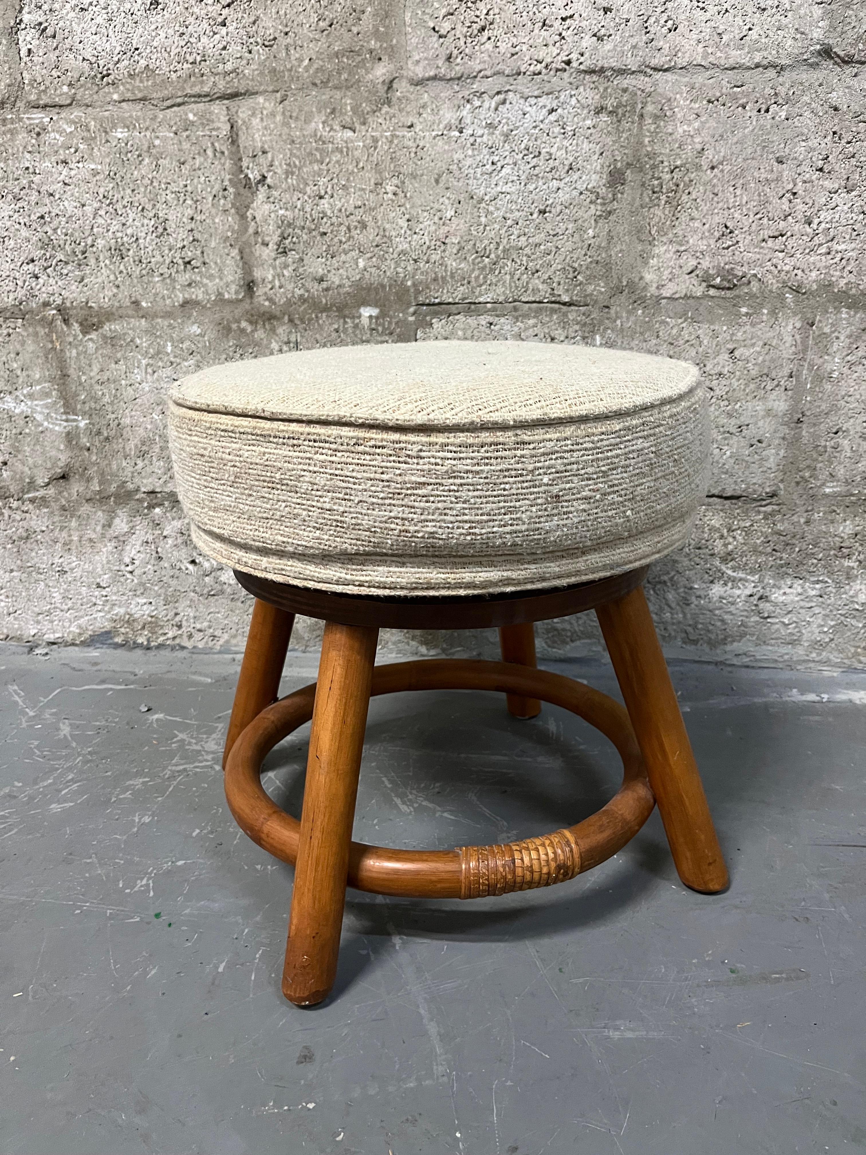 Vintage Bamboo Rattan Wicker Swivel Footstool /Ottoman in the Paul Frankl's Style by Classic Rattan Inc. Circa 1970s
Features a swivel cushion with the original cream upholstery and a Boho Chic style rattan frame.
In Good Original Condition with
