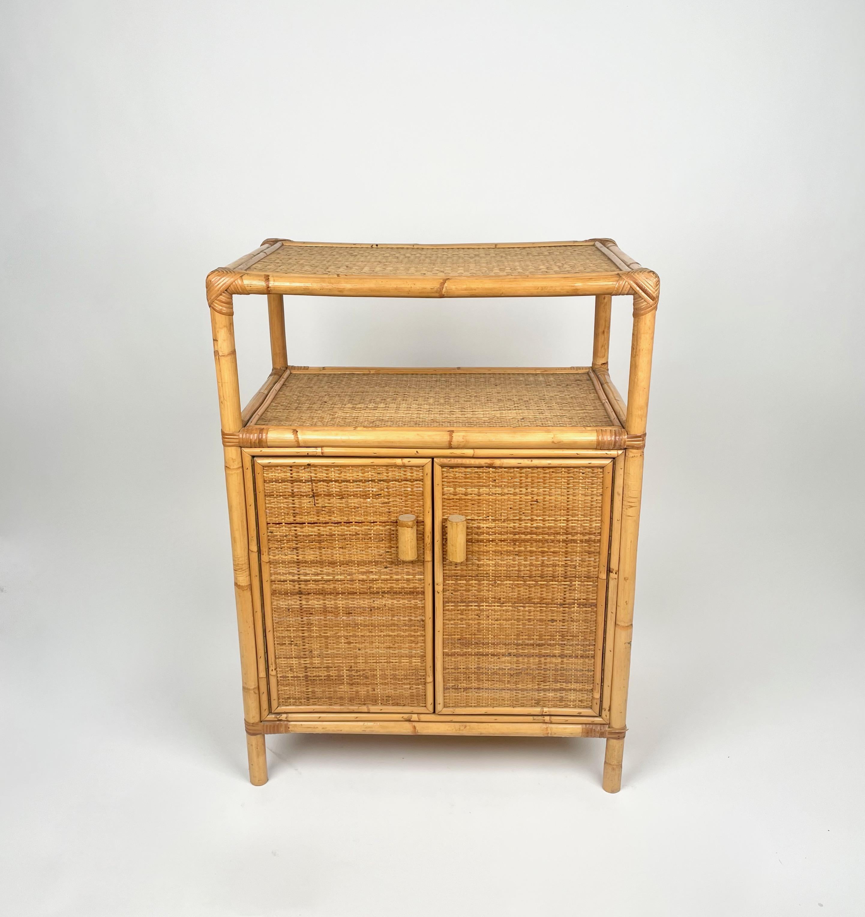 Vieille console à tiroirs en rotin et bambou avec détails en bois, fabriquée en Italie dans les années 1970.

Le tiroir intérieur est divisé par une étagère en bois. 

Cette belle pièce vintage sera un bel ajout à utiliser dans une salle de