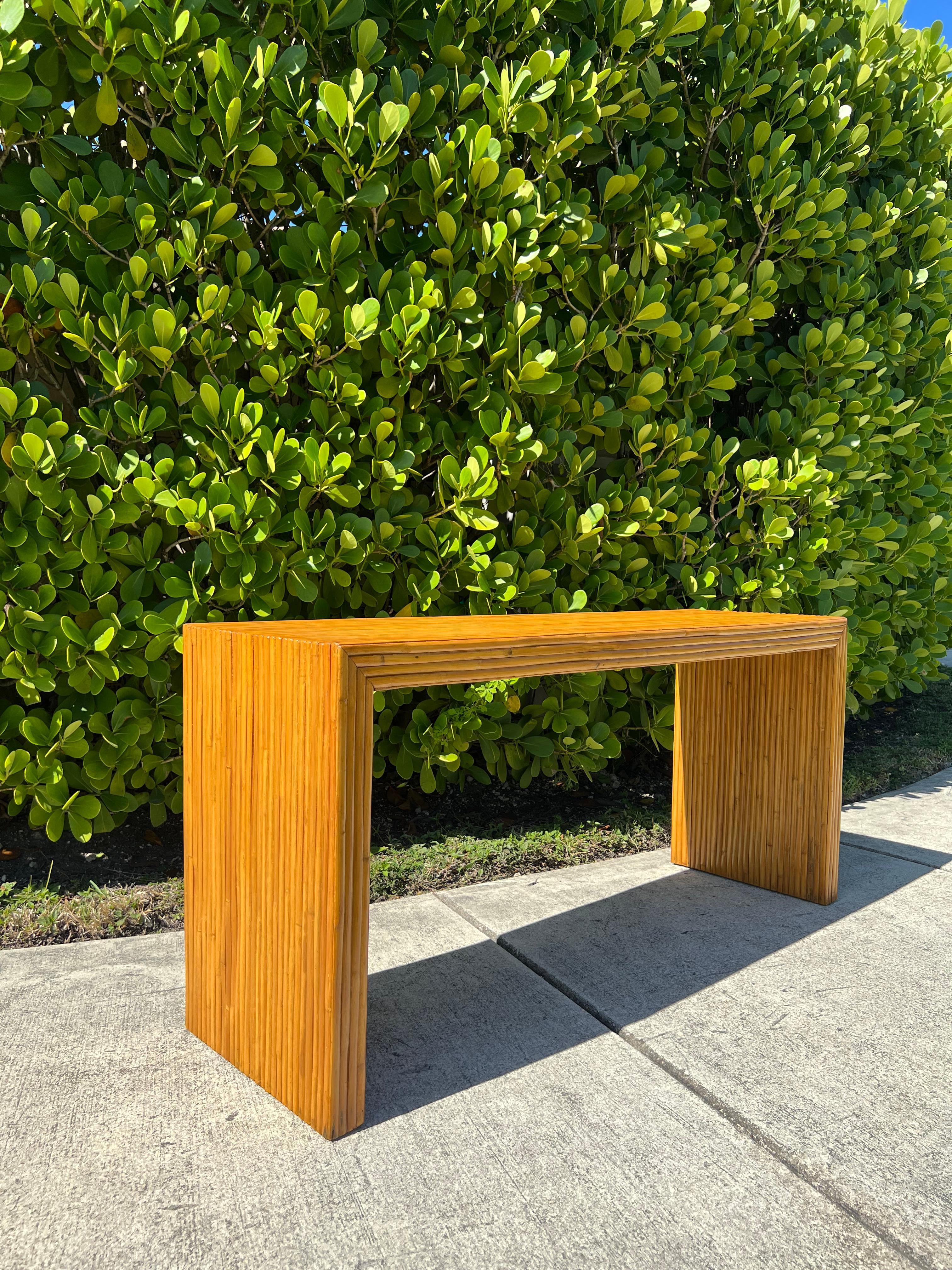 Available is a beautiful split bamboo Parsons console table. This piece has been newly refinished and is in excellent condition, an amazing natural texture to add to a wall or behind a sofa.