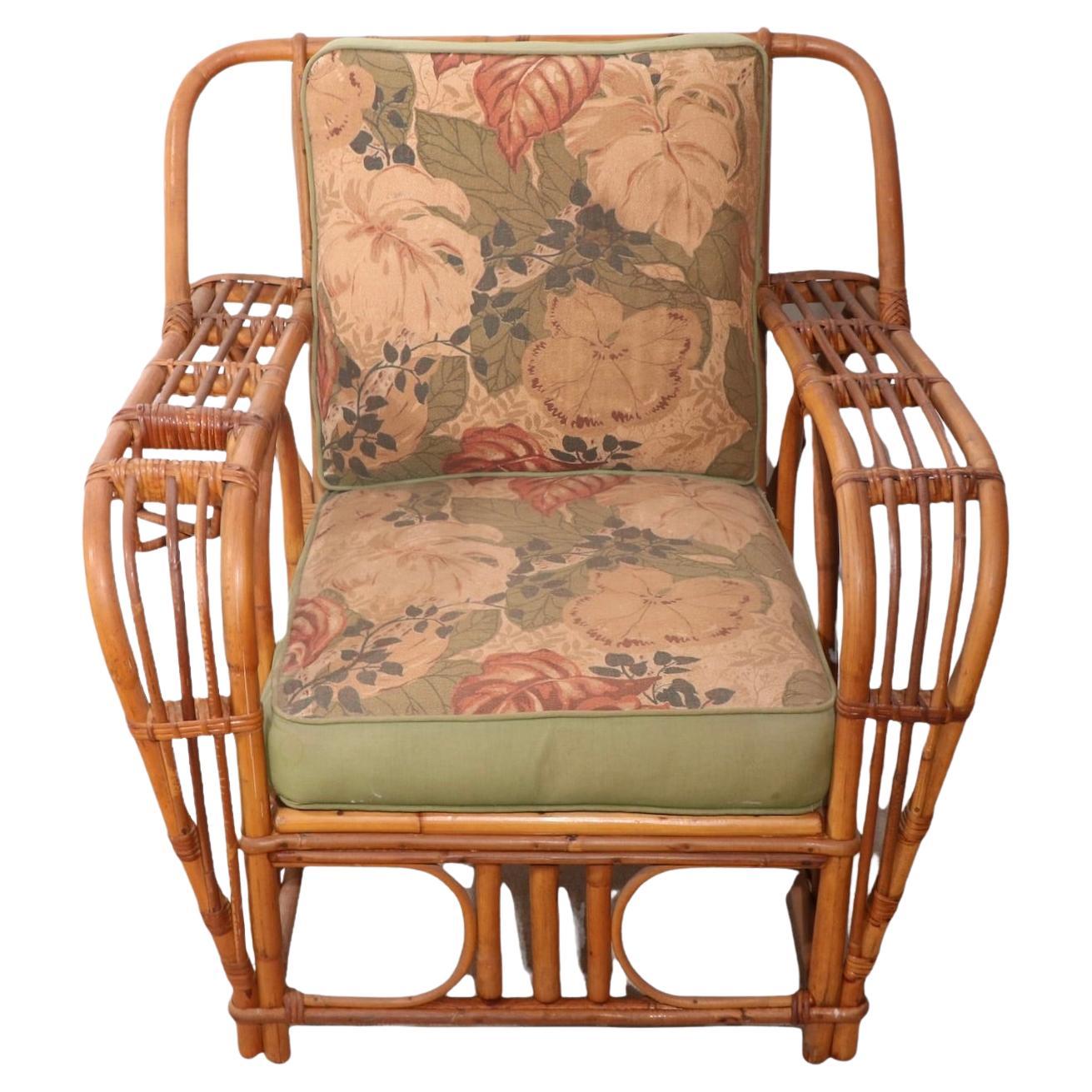 Exception bamboo and reed lounge chair with dramatic wide arms, including a drink holder built into one arm. Designed for style and relaxation, this gem is in very good, original clean condition, however the cushions are faded and do show signs of