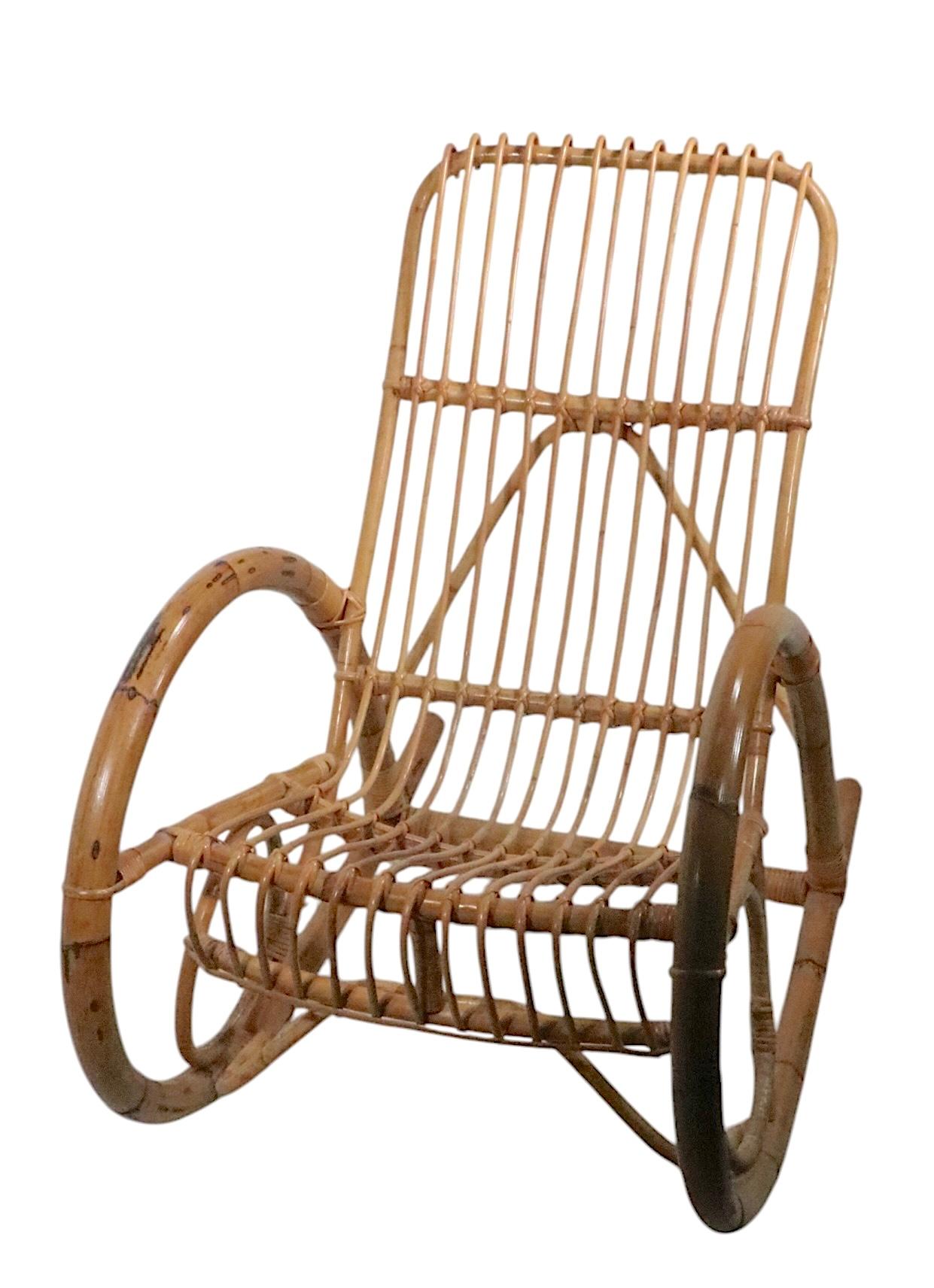 Sedia a dondolo chic di metà secolo in bambù, realizzata in Italia e attribuita a Franco Albini. Questa sedia chic è in ottime condizioni originali e presenta solo una leggera usura estetica, normale e coerente con l'età.
 Totale H 36,5 x Braccio H