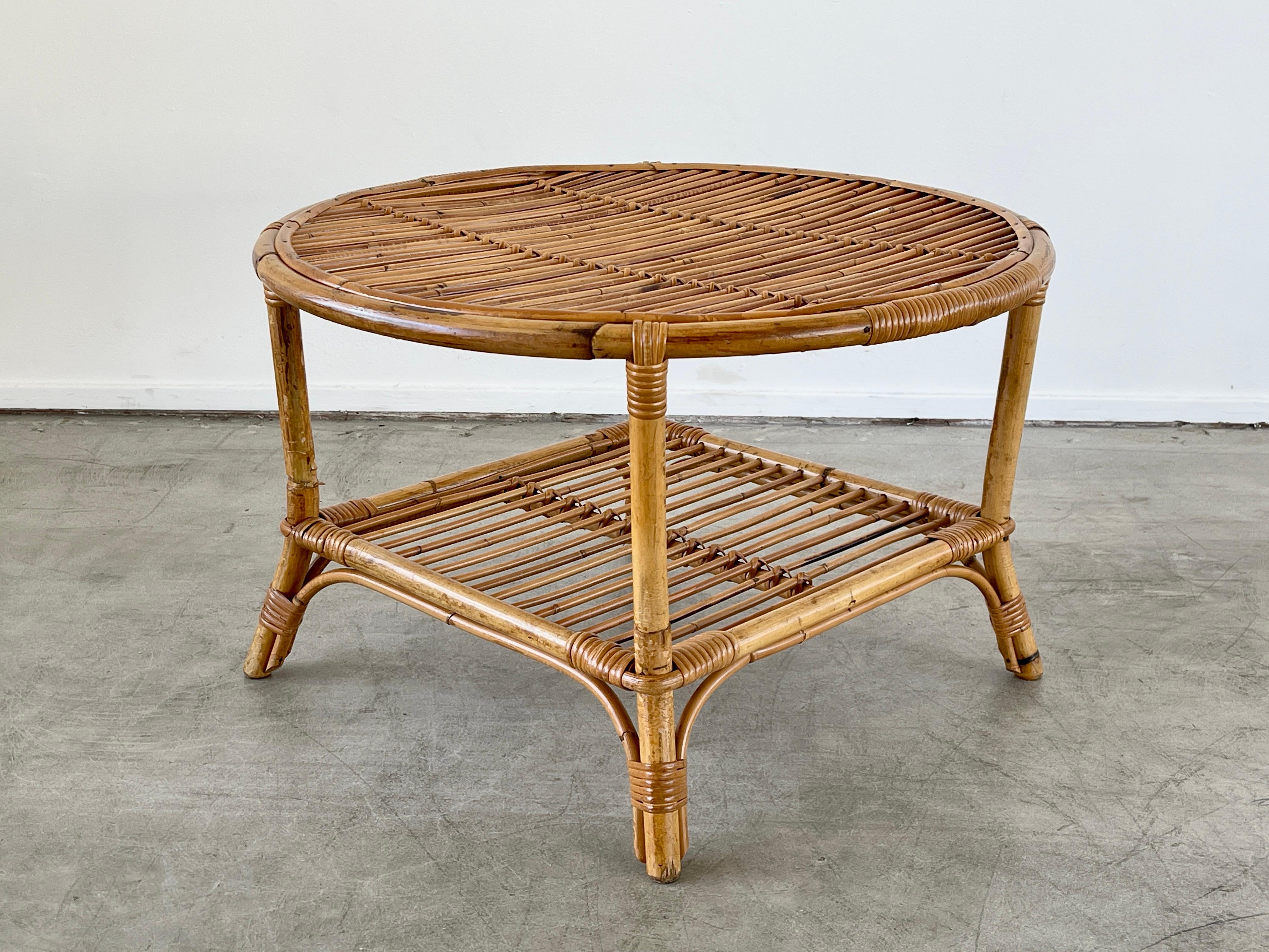 Great circular bamboo rattan table with four legs and slatted bamboo top and shelf.