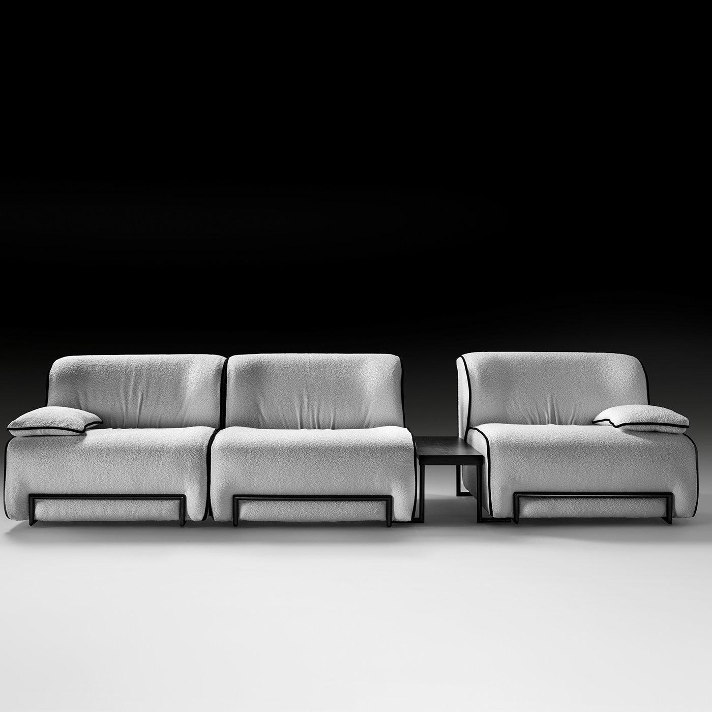 This sofa has a clean and minimal design, and features a composition with two seats on the left (each measuring 100x100 cm) connected to the single seat on the right (100x100 cm)by means of a small table (35x78 cm). The structure is made of poplar