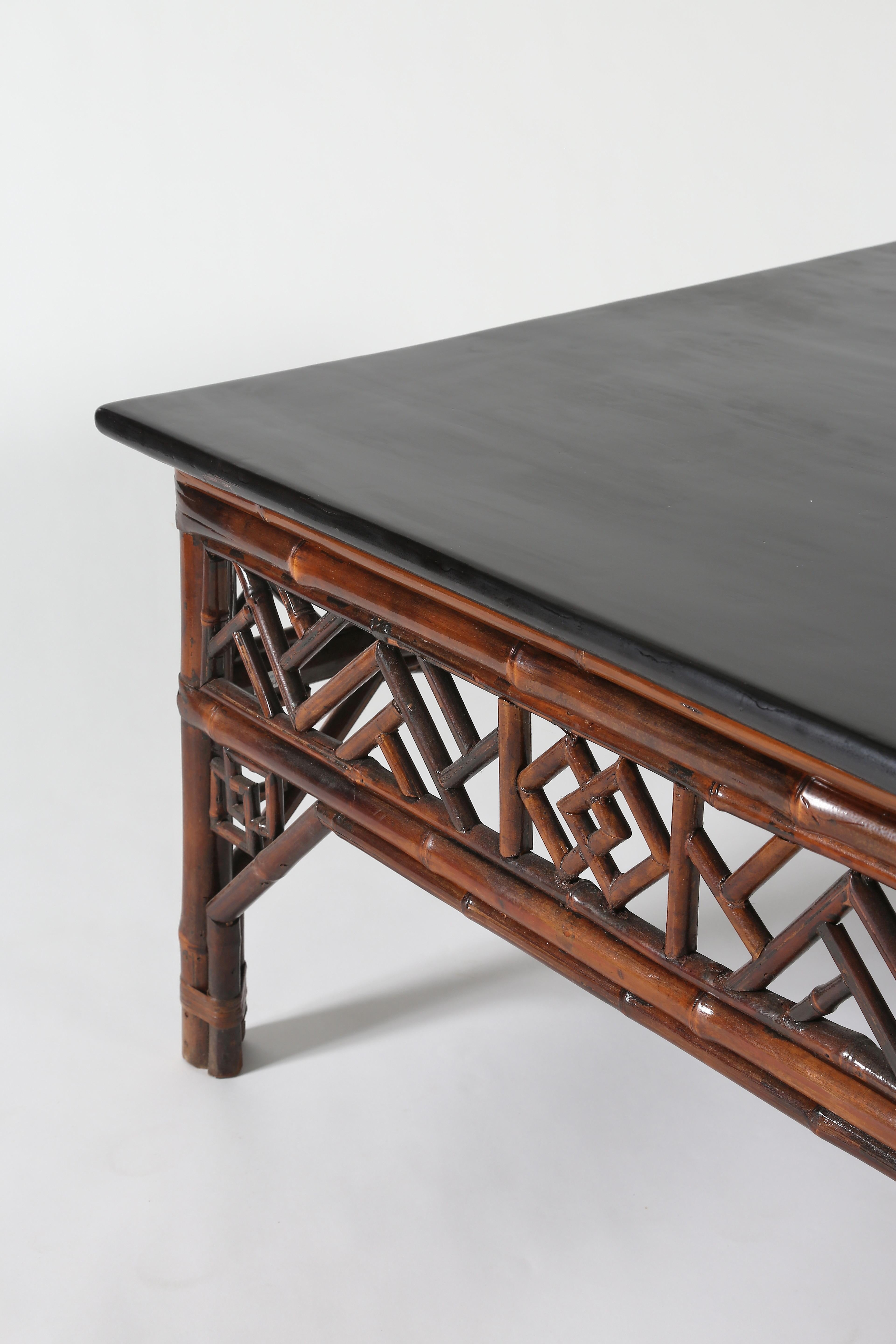 The black lacquer paneled top protruding over wrapped around stretchers, enclosing lattice panels , all standing on straight bamboo legs reinforced by arch apron with reticulated spandrels

Bamboo and black lacquer over wood
Shanxi Province,