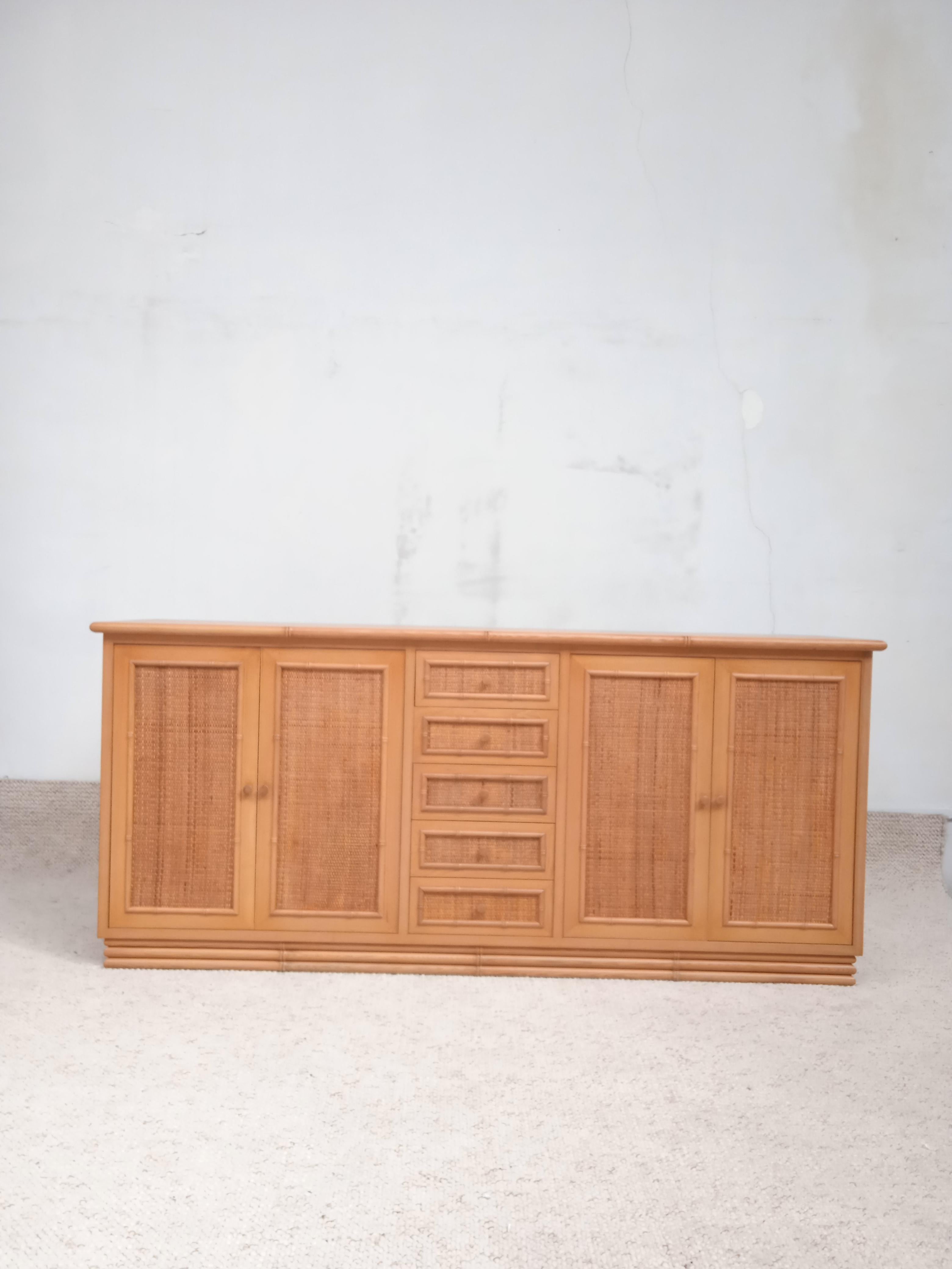 Bamboo style sideboard with rattan details 1970. In solid wood, atributed to Giorgetti. 
This sideboard features a sturdy bamboo style frame. It shows rattan panels on drawers and doors. Despite slight traces of use, the wood is in good condition