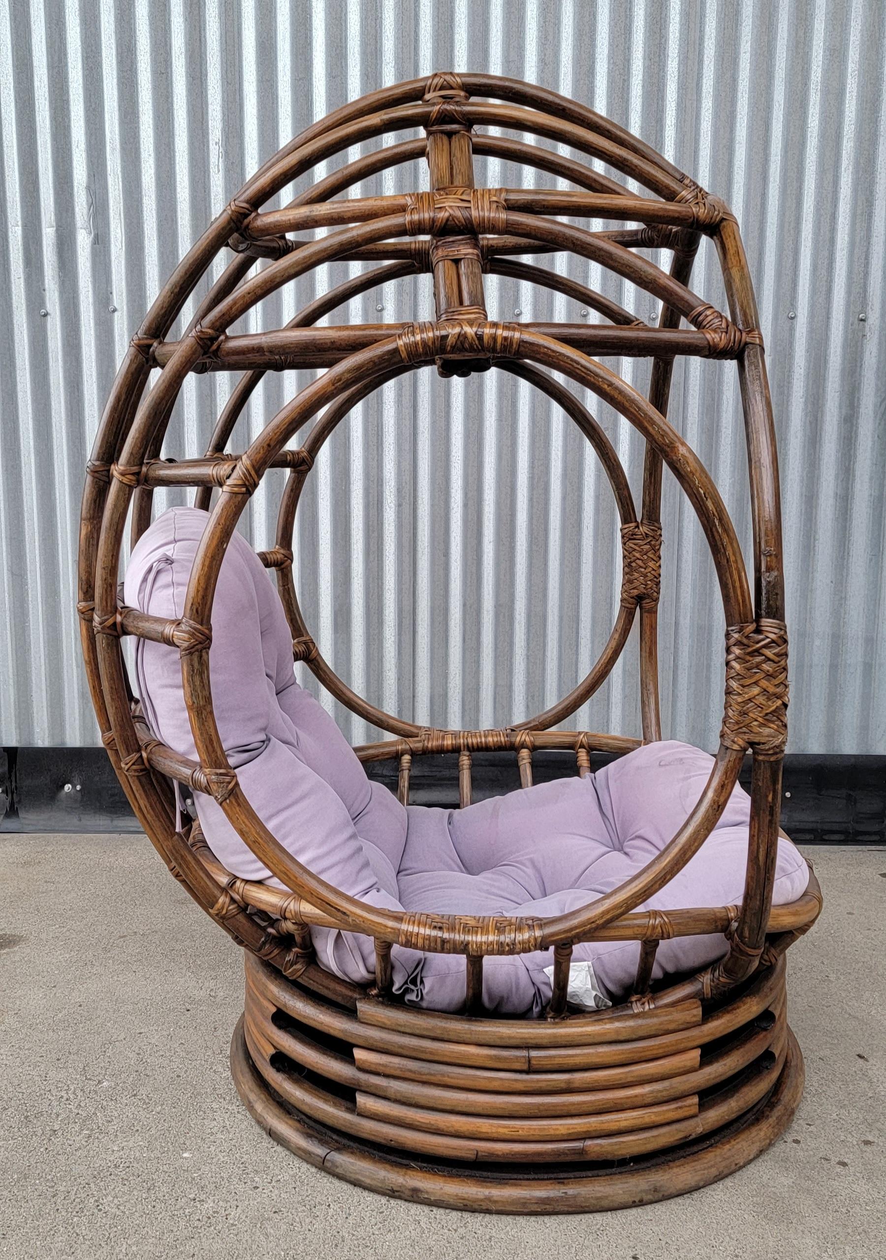 An uncommon bamboo / rattan swivel egg chair. Structurally very solid, swivels easily. Loose, reversible cushion easily replaced. Seat height measures 16 inches at front of seat. Nice statement piece for a Mid-Century Modern or Organic Modern home
