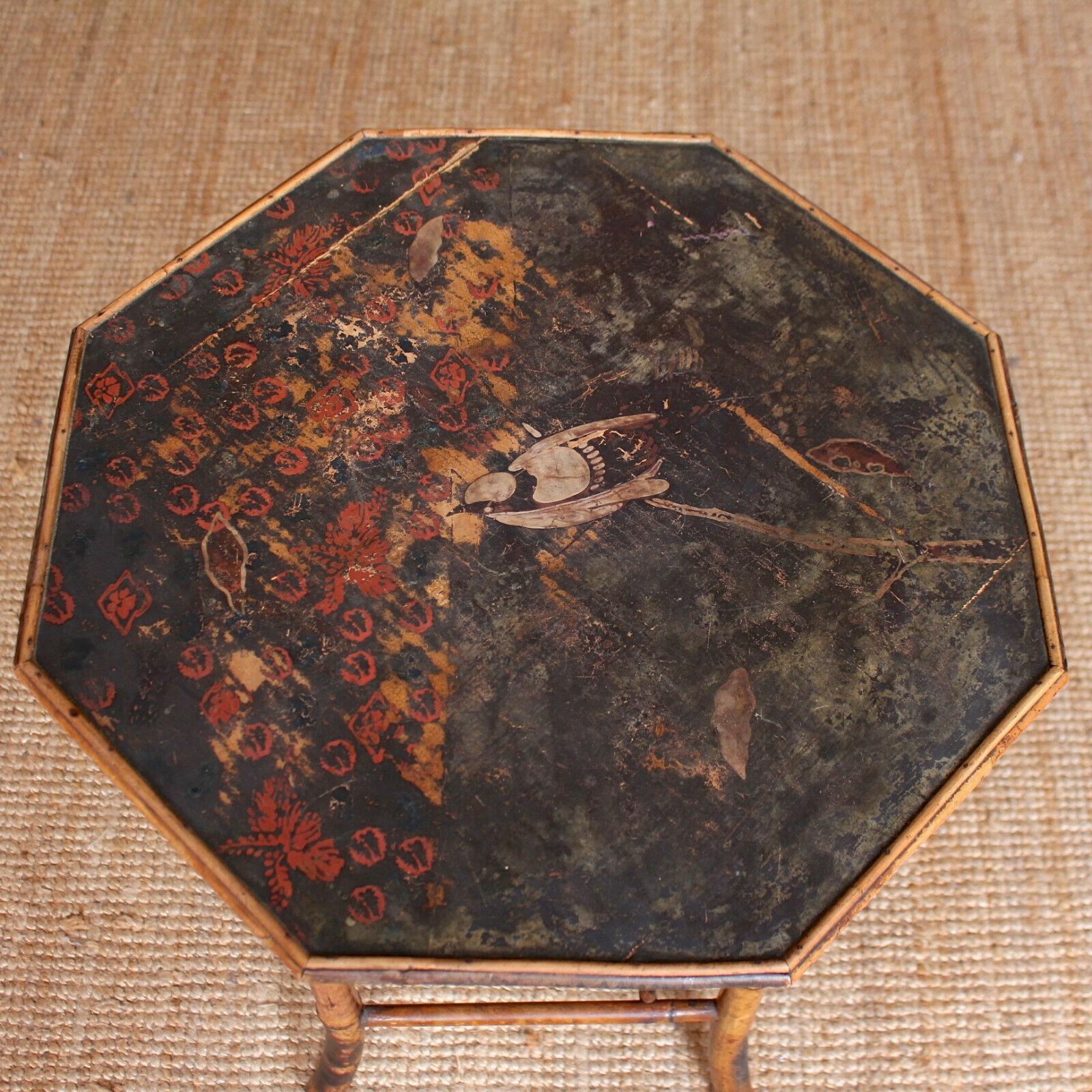 19th century octagonal burnt bamboo lamp table.
The lacquered tray top with bird decoration raised on bamboo cane legs with splayed feet, joined by canework lattice stretchers.