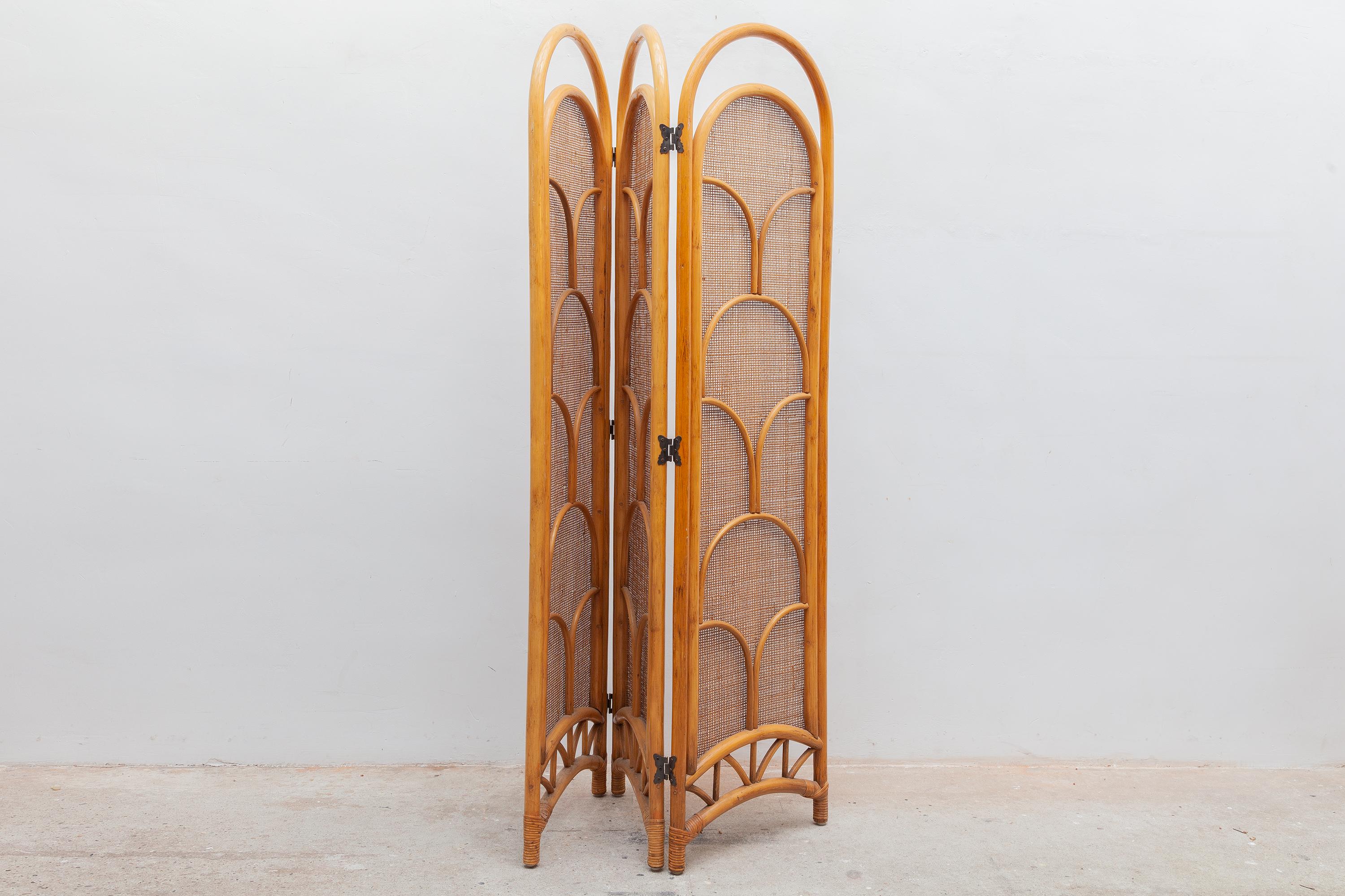 Vintage bamboo room screen. Three panels with caned mesh and decorative butterfly shaped hinges. Dimensions: 134 W x 175 H x 4 D cm.