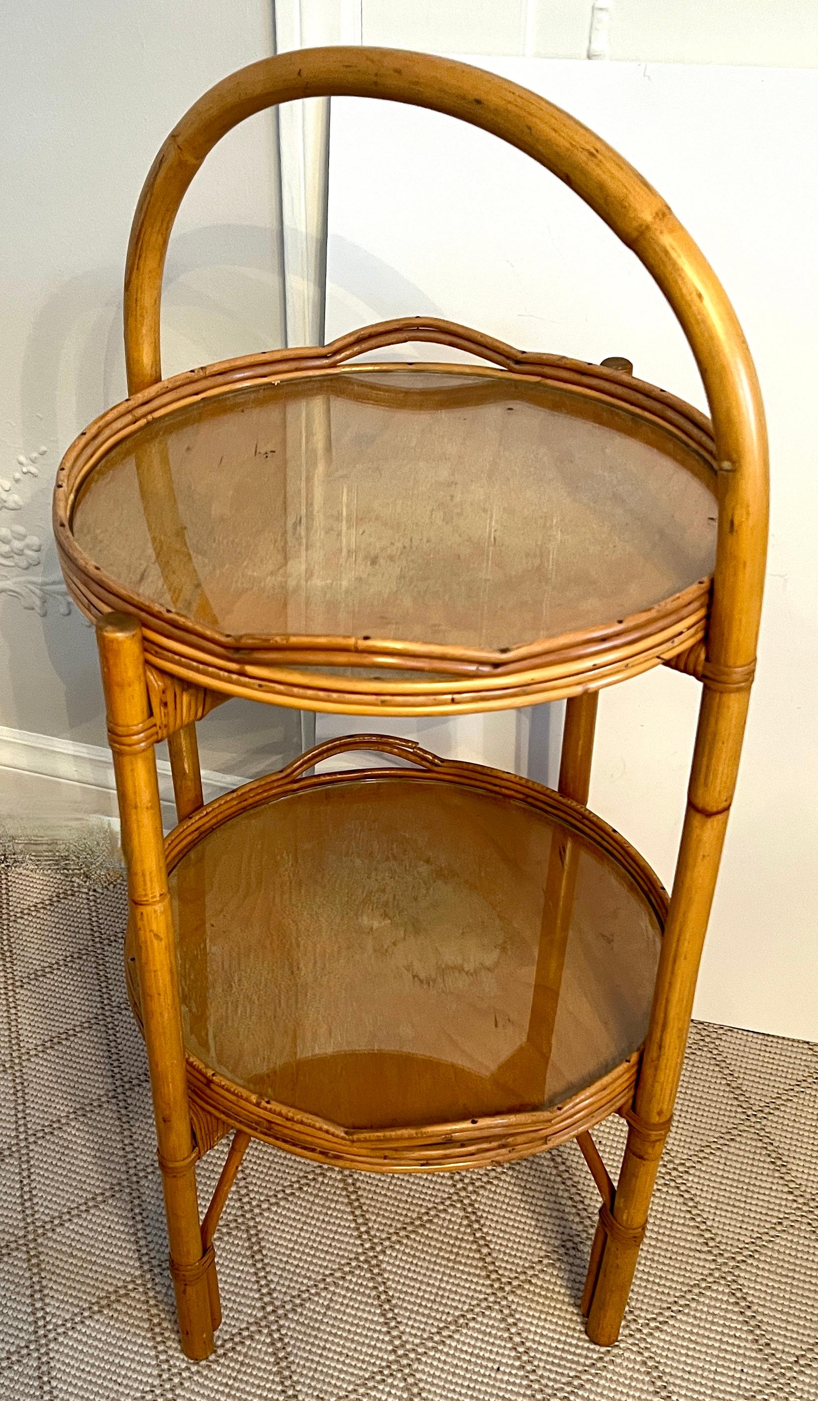 A unique two Tier Tray table made of Bamboo and Pencil rattan.   Hand crafted and in very good vintage condition.  The Stand holds two trays that are removable and then folds for easy storage.

The perfect addition for an impromptu cocktail party or