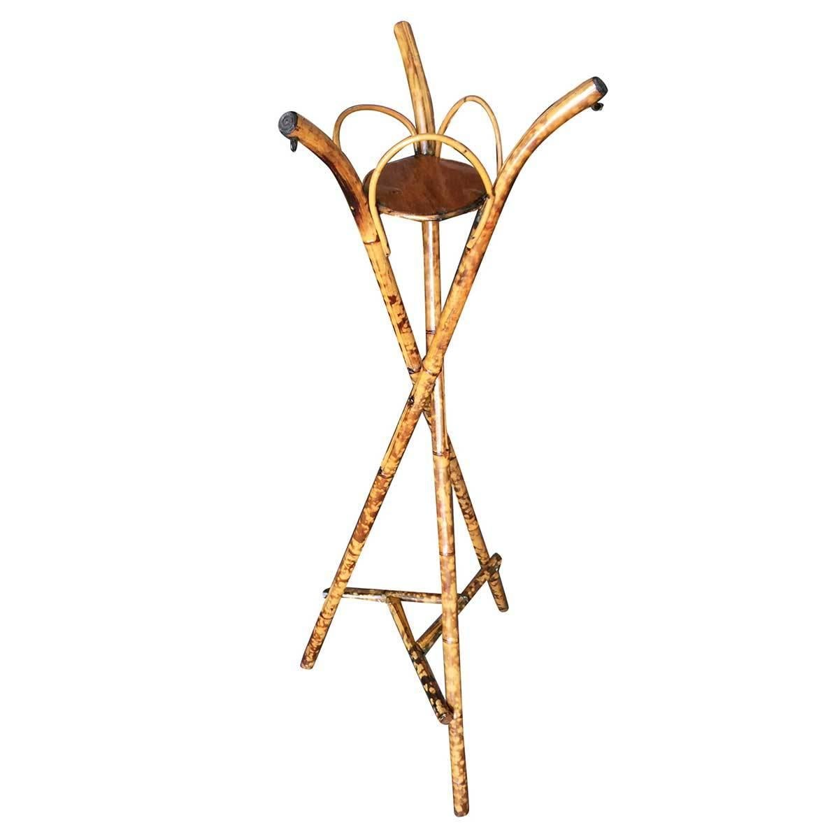 Late Victorian tripod plant stand featuring three crossing Tiger Bamboo legs with a single small circular wood shelf. An extremely charming and rare piece. 

Designed in the manner of Paul Frankl.

Restored to new for you.

All rattan, bamboo and