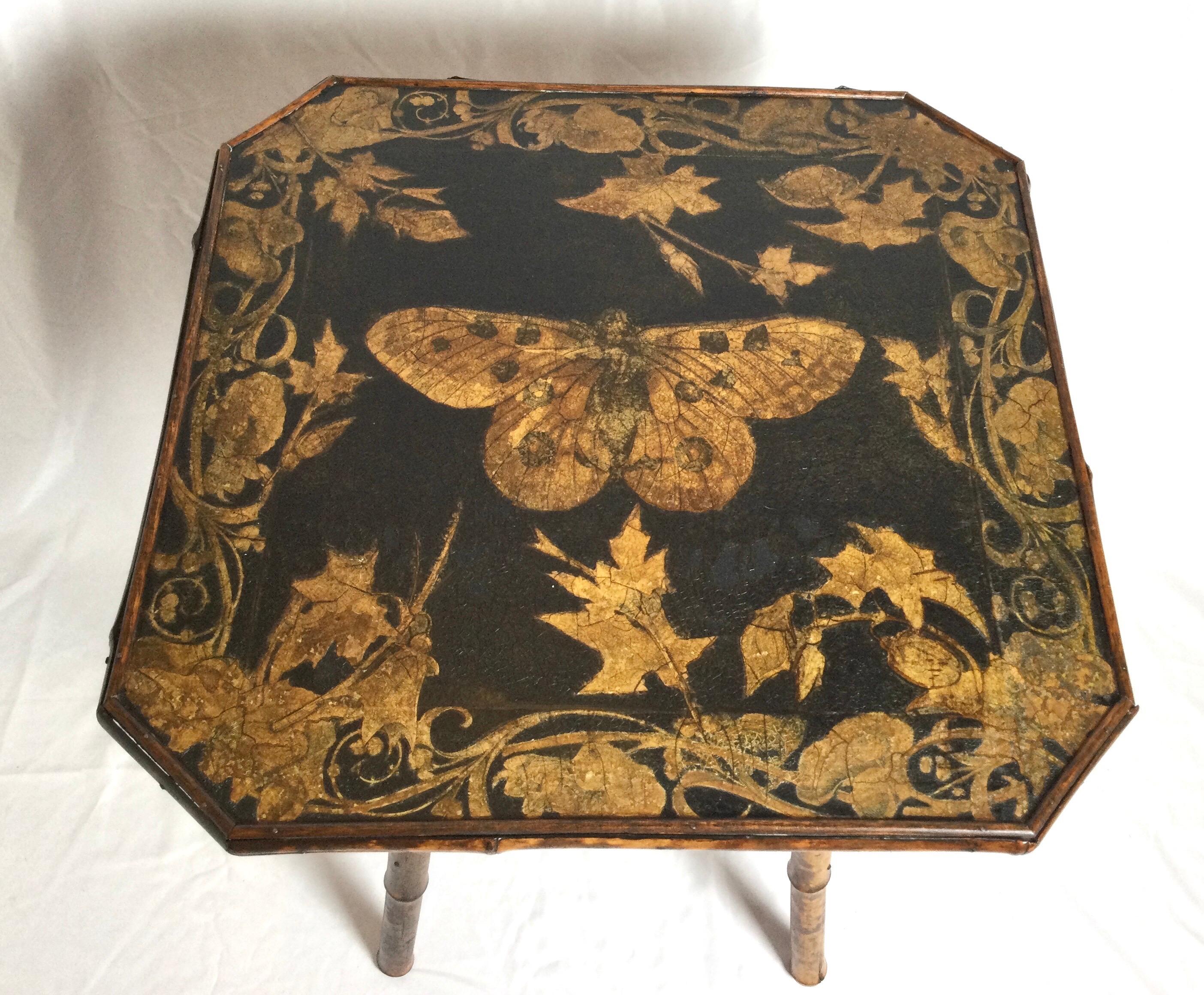 An octagonal shaped bamboo and painted wood Aesthetic movement tiered table. The top and lower shelf with painted butterfly with foliate surround. The legs and trim in authentic bamboo. Circa 1875.