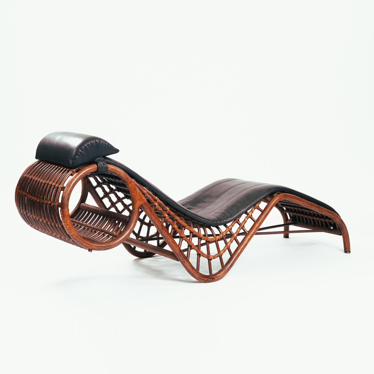 Beautifully shaped vintage chaise longue/daybed from Flechtatelier Schütz from the 1970s, Germany. This rare chaise longue is made of bamboo/rattan with black leather upholstery. The pillow can be removed from the chair. Can be tilted backwards for
