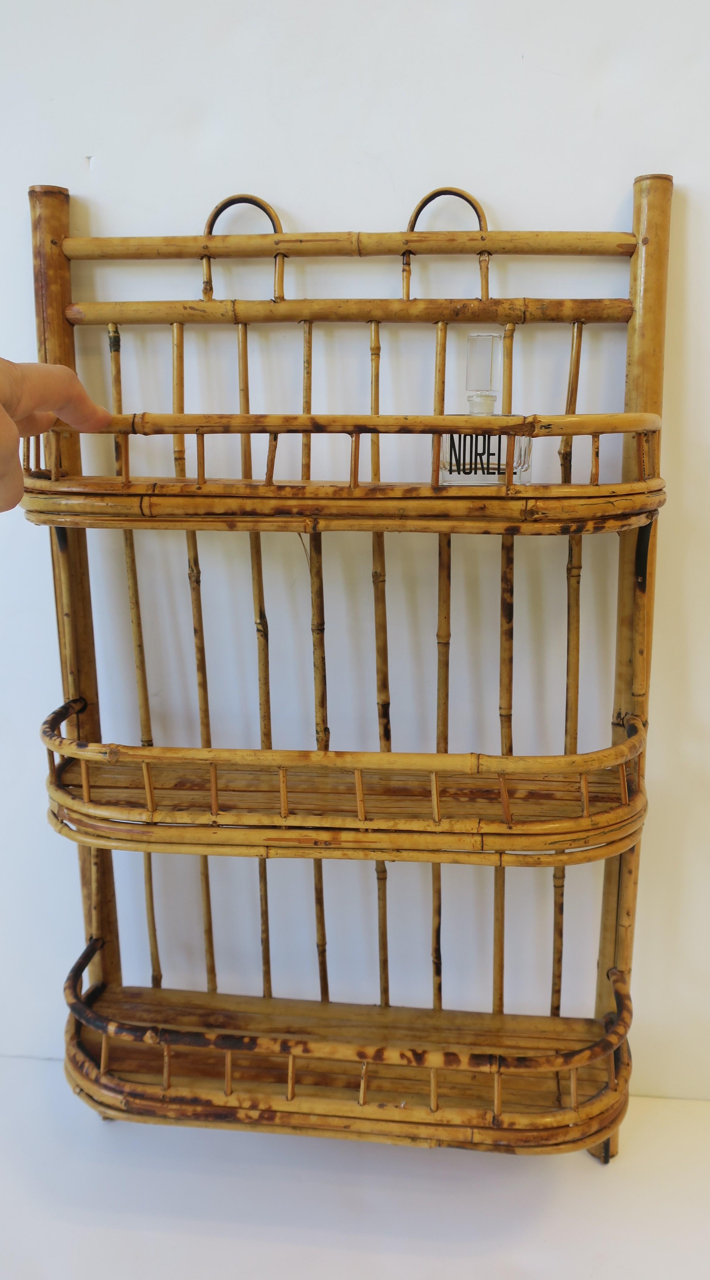 A vintage bamboo wicker wall shelf with three shelves great for holding kitchen or bathroom items, circa late 20th century. A great shelf for spices or perfume. Plenty of ample space; please see measurements below. This wall shelf has three shelves