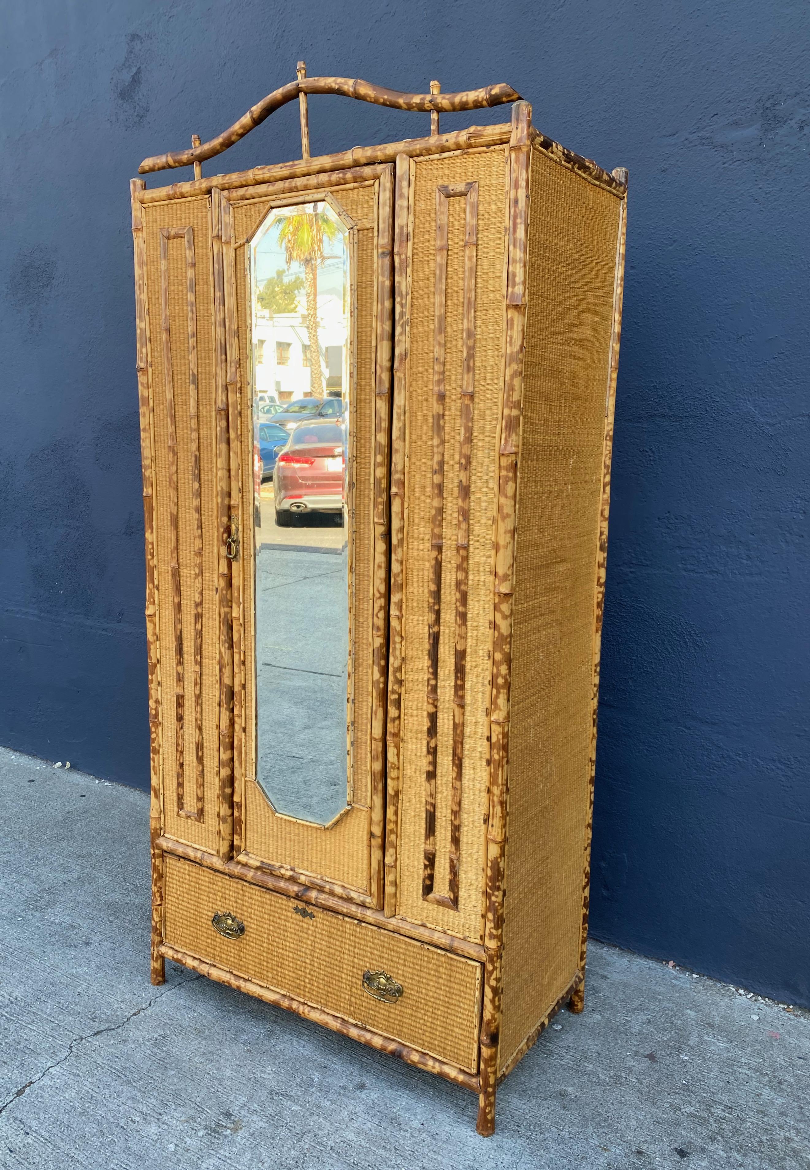 This is a charming late 19th century English bamboo wardrobe or armoire. All elements of the wardrobe are original and in very good condition. The wardrobe features a top section with shelves for storage (it could be fitted with a rod for hanging