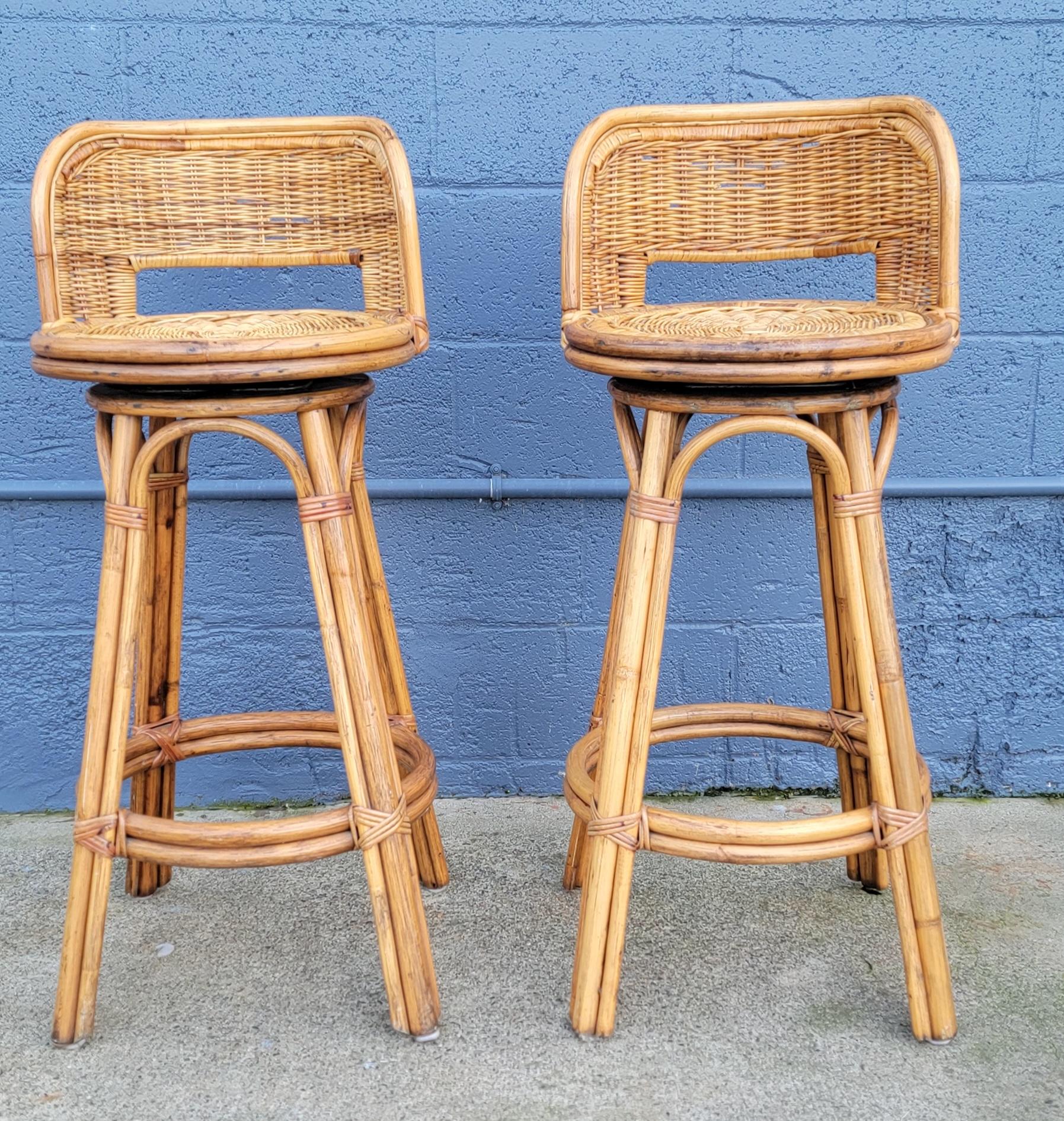 A pair of bamboo and woven wicker bar stools with swivel feature and seat backs. All bindings intact, sturdy construction. In very good to excellent original condition.