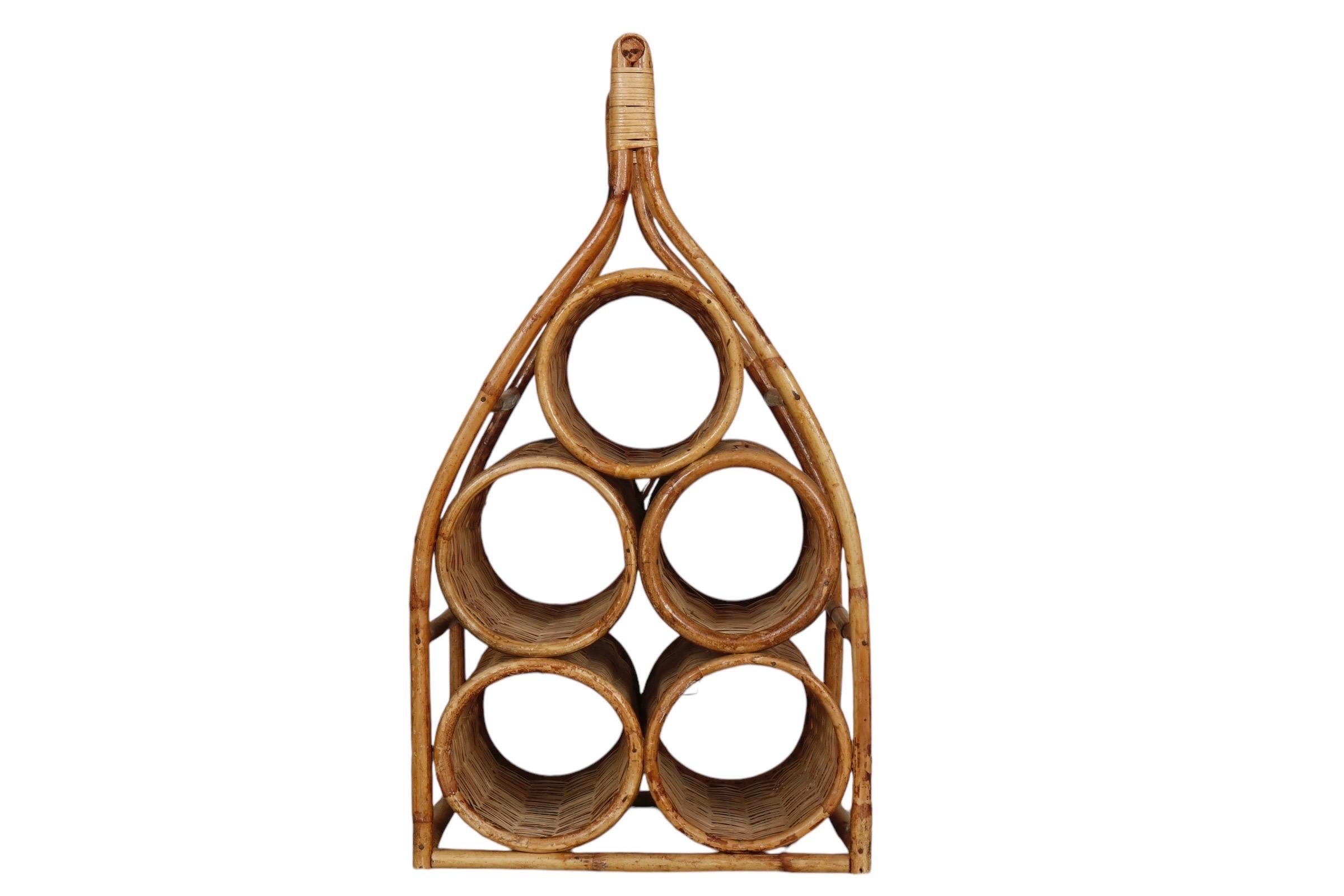 A sculptural wicker woven rattan wine rack with a bamboo frame. Holds five bottles in a loosely wine bottle shape.

