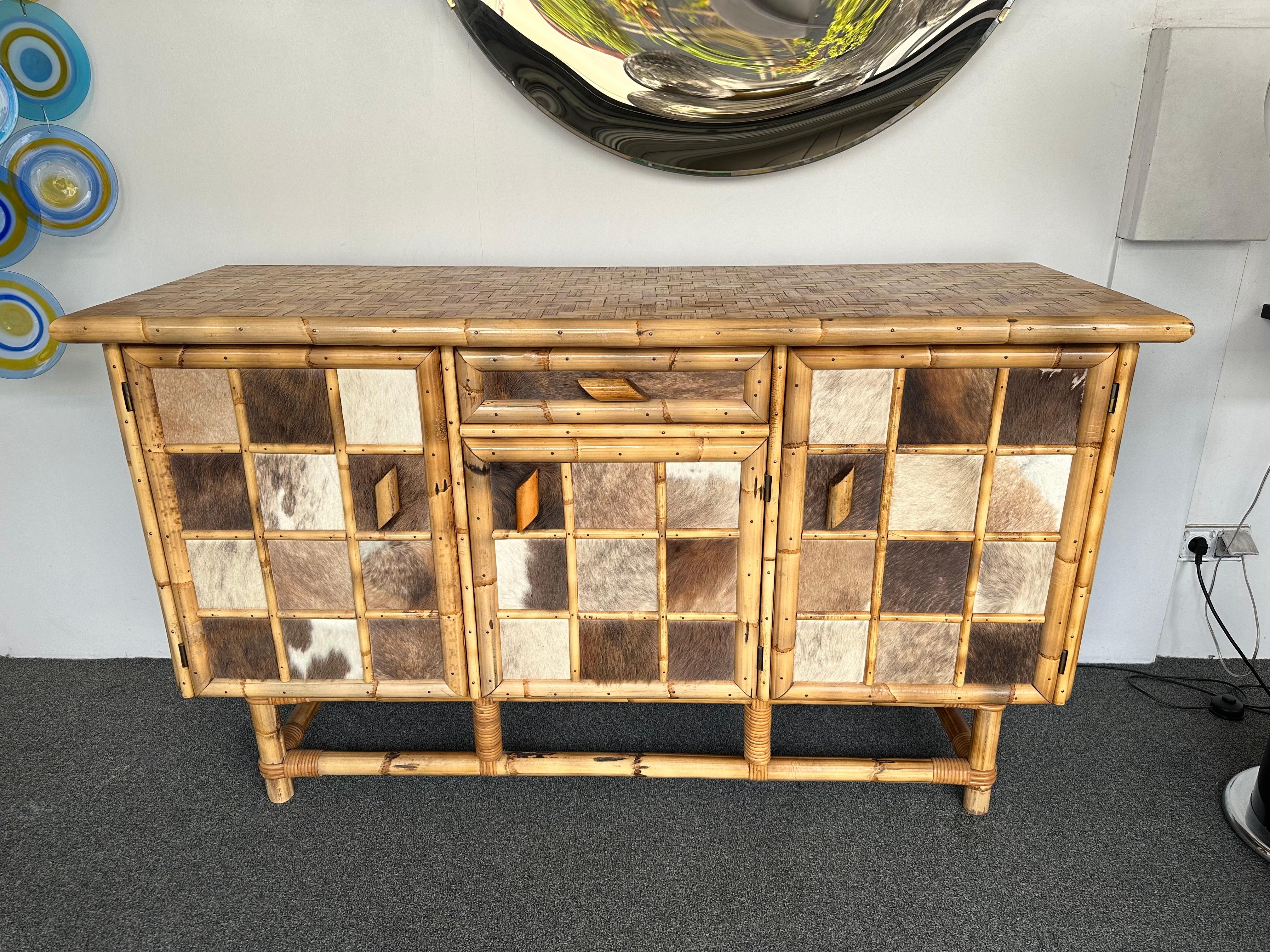 Mid-Century Modern Dry bar cabinet or buffet credenza in wood, bamboo, bamboo marquetry, doors decor with cow leather, glass shelf. Italian design attributed to the manufacture Dal Vera for the very typical marquetry top. Famous design like Mario
