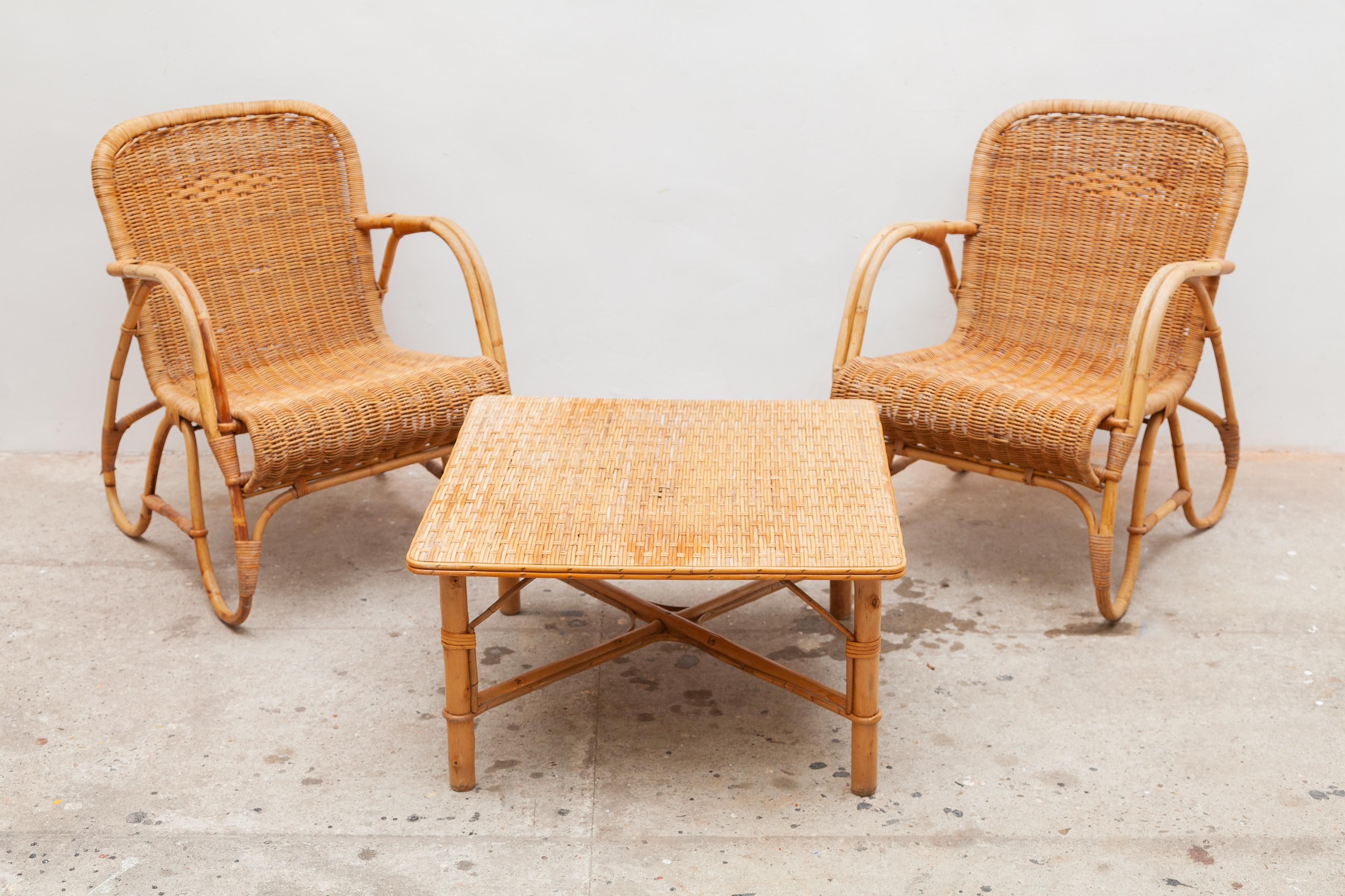 Vintage midcentury bamboo lounge chairs and table set. Woven rattan seats and tabletop.
Dimensions: Chairs 55 W x 72 H x 70 D cm, seat 35cm high, table 65 W x 37 H x 65 D cm.