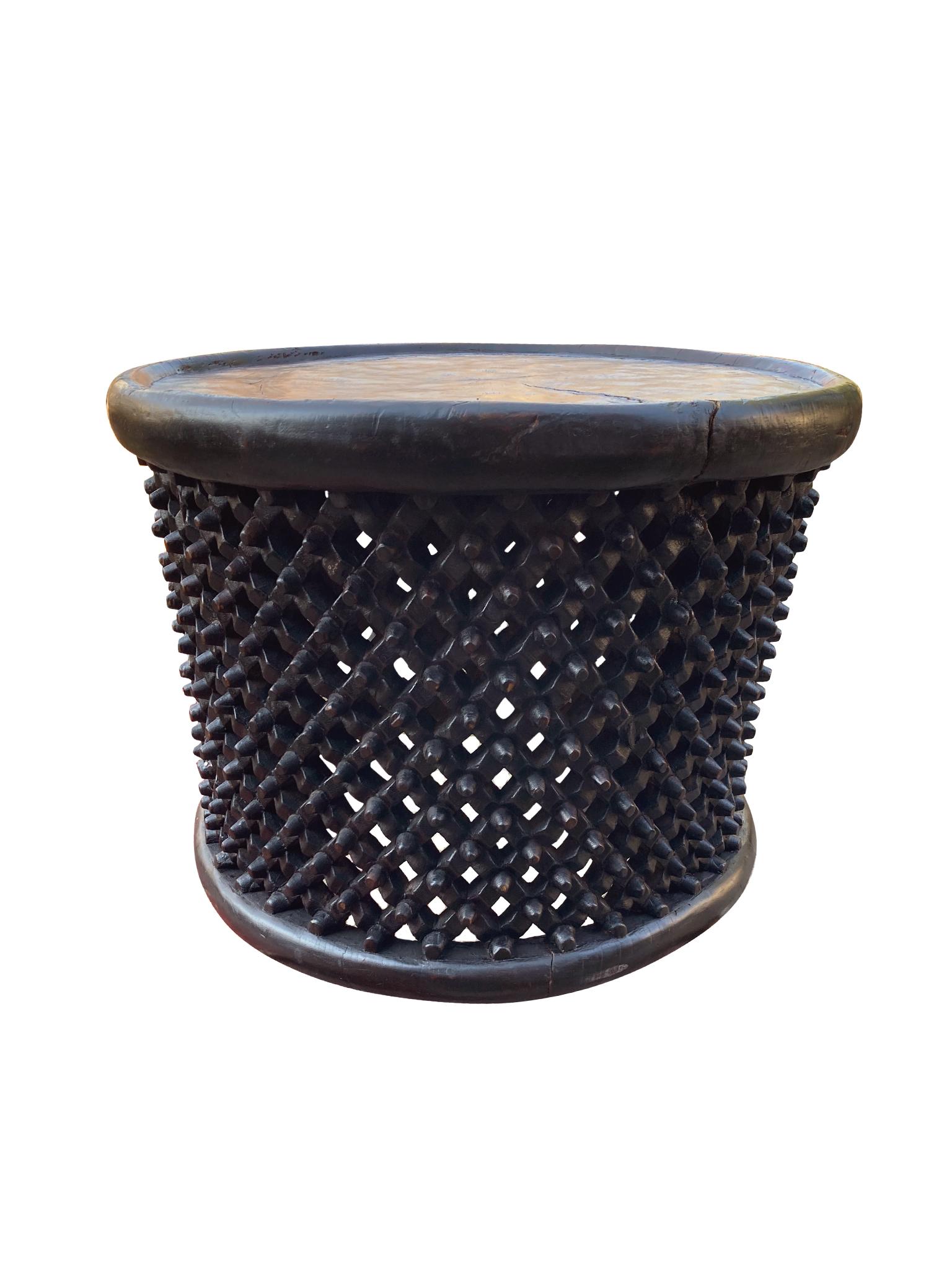 Hand-carved wood Bamileke table from Cameroon, mid-late 20th century. The body of the table is intricately carved with a lattice-like design. We love the smoothed edges of the top and the overall organic textures and tone of the