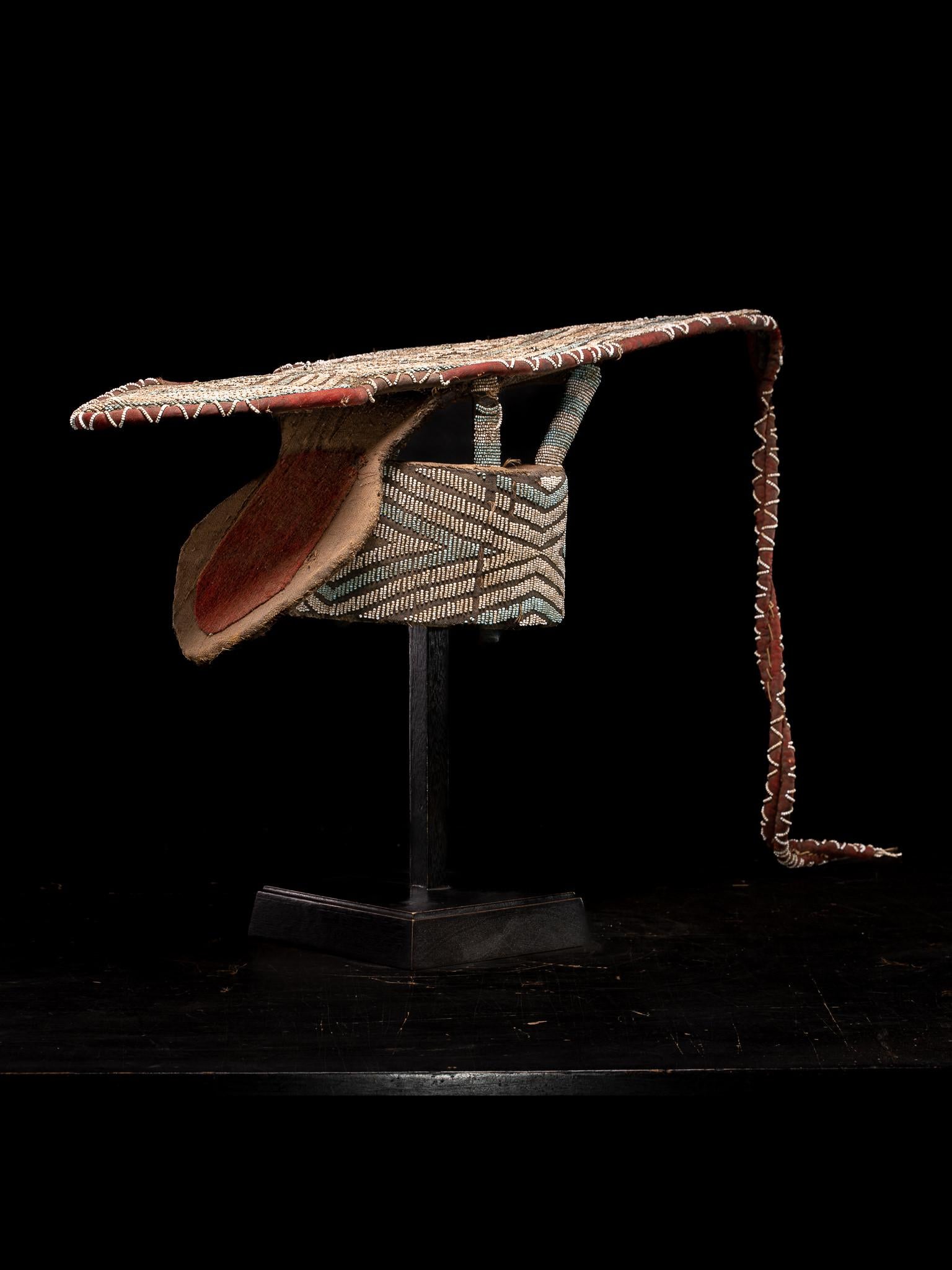 Escudo de Danza Decorativo Bamileke, bordado con Cuentas de Vidrio Europeas, Pueblo de las Praderas, Camerún. 

Colección privada Bruselas 

La tablilla de rafia está recubierta de tela y miniaturas de cuentas de cristal de diferentes formas y