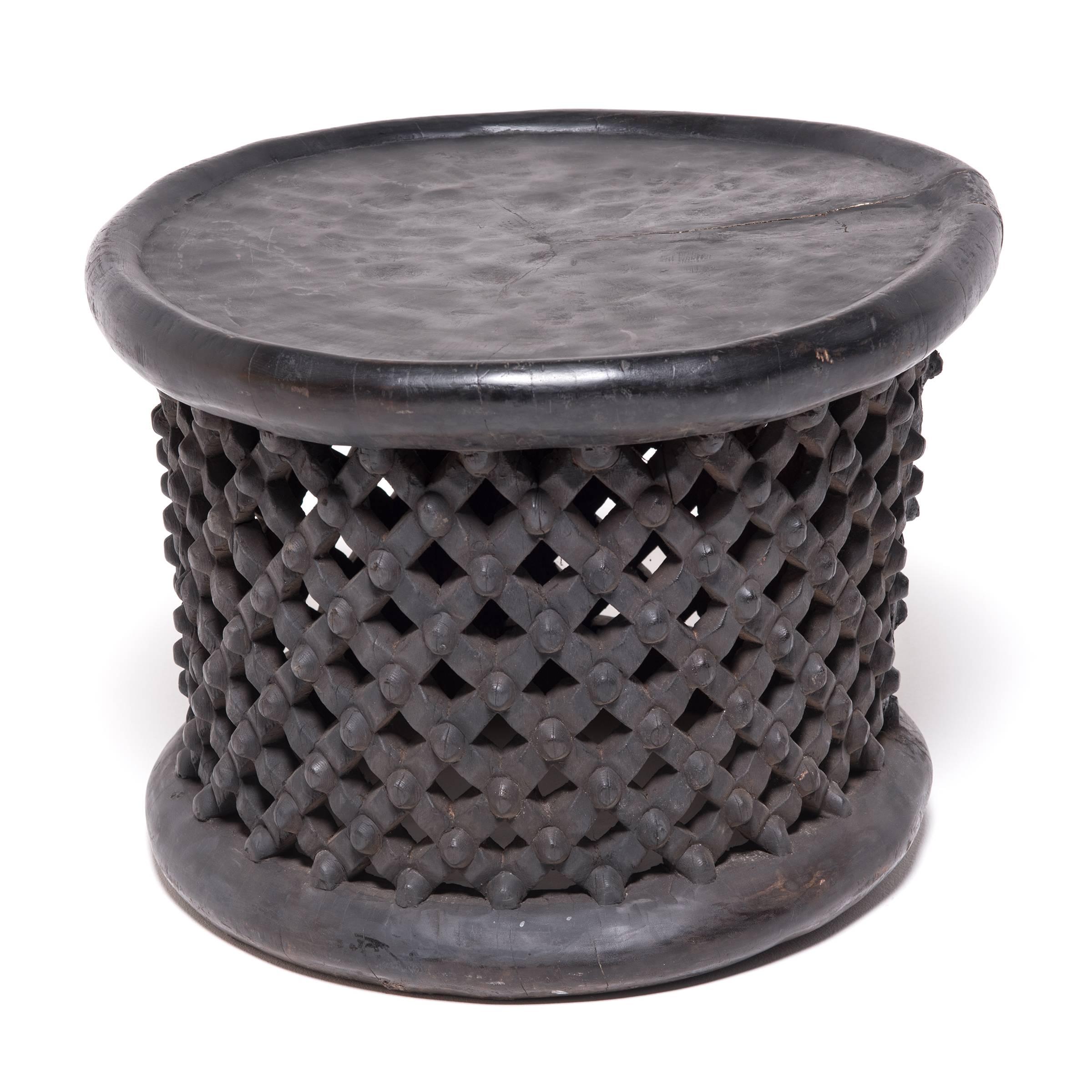 Carved from a single tree trunk, Bamileke lattice stools were used in Cameroon as symbolic seats in public ceremonies. The lattice webbing represents both the life cycle and the divine wisdom of the earth spider. A stool with broken lattice was
