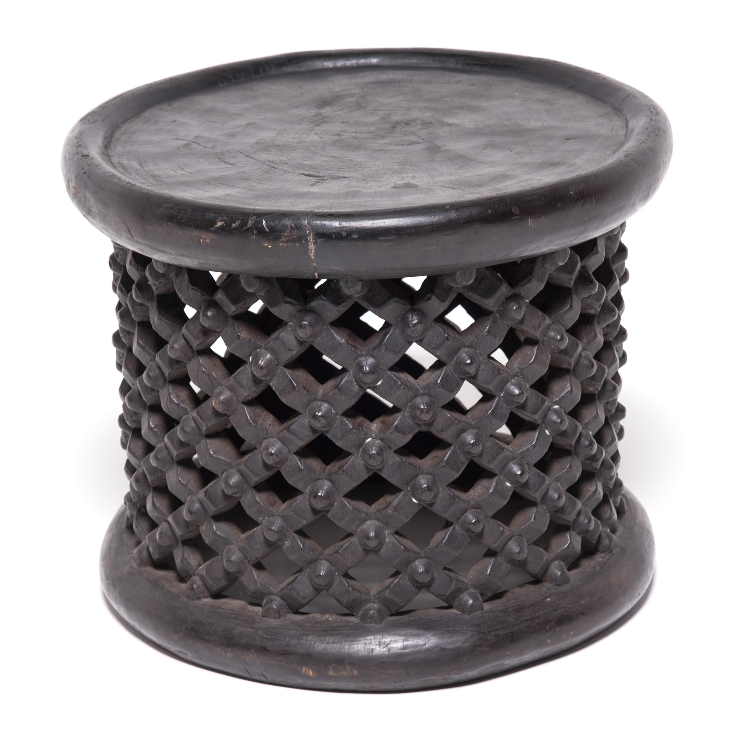 Carved from a single tree trunk, Bamileke lattice stools were used in Cameroon as symbolic seats in public ceremonies. The lattice webbing represents both the life cycle and the divine wisdom of the earth spider. A stool with broken lattice was