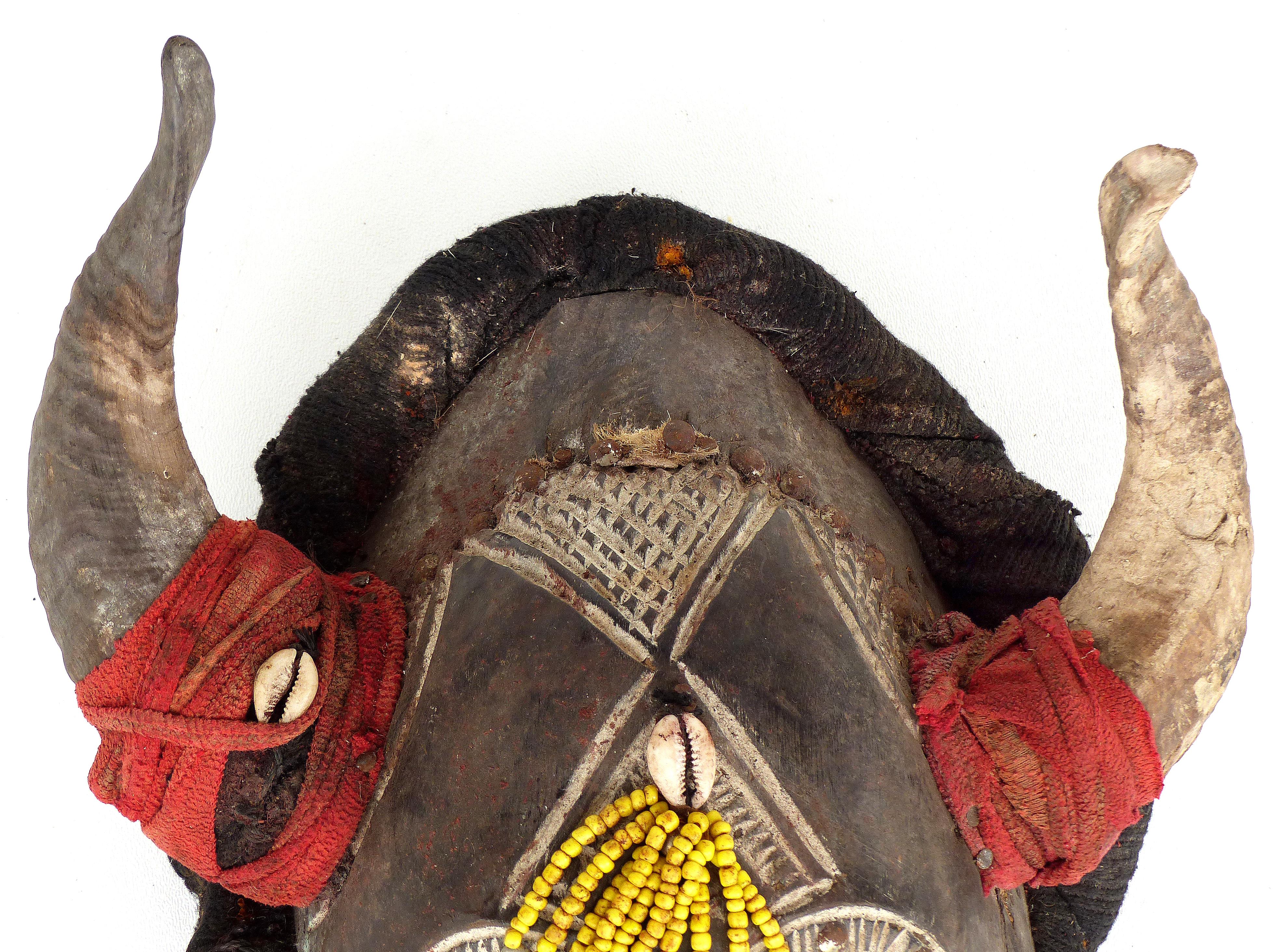 Bamileke Horned Tribal Mask from Cameroon, Africa

Offered for sale is a decorative carved mask from the Bamileke people of Cameroon, Africa. This interesting and unusual horned mask is embellished with beads, a bamboo beard, cowry shells, leather