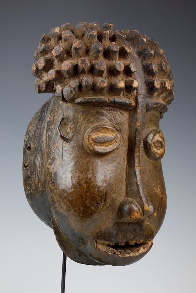 This fine and early Bamileke mask, carved from a heavy hardwood, features a vibrant expression. The surface of the mask exhibits a deep, well-worn patina.

The mask was originally purchased from Sotheby’s London in 1979 (lot 107) by the owner of the