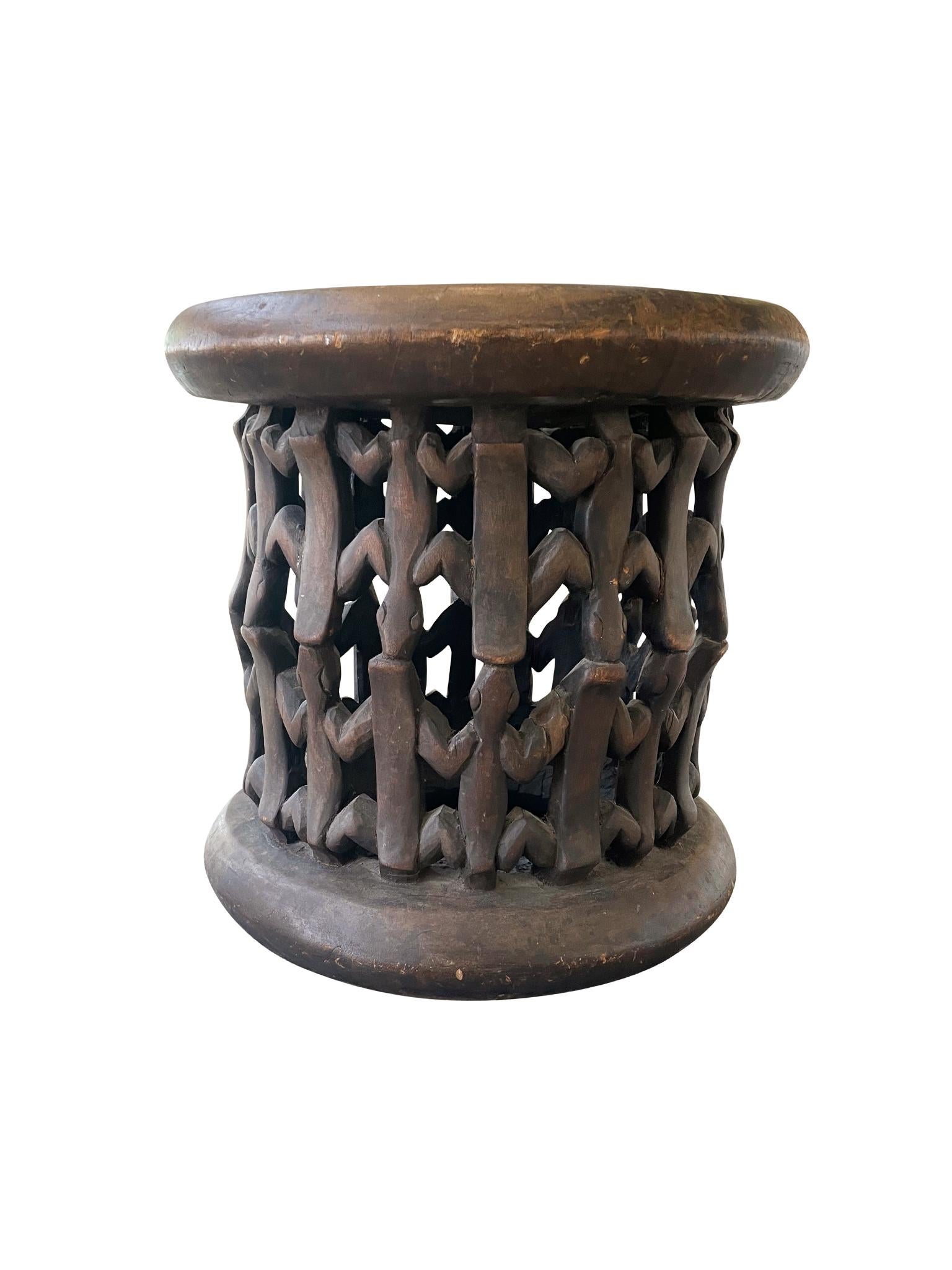 Hand-carved wood Bamileke table from Cameroon, Mid-Late 20th Century. The body of the table is intricately designed with a network of lizard motifs. We love the smoothed edges of the top and the overall organic textures and tone of the